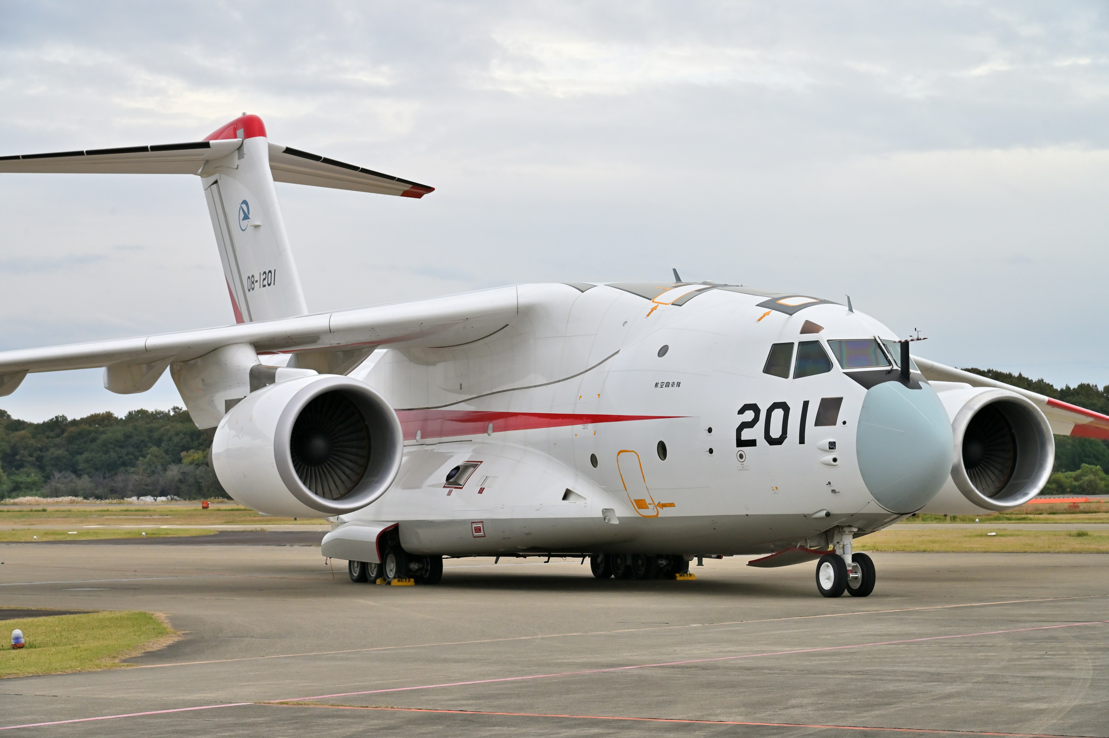 White aircraft with number 201 parked on the runway