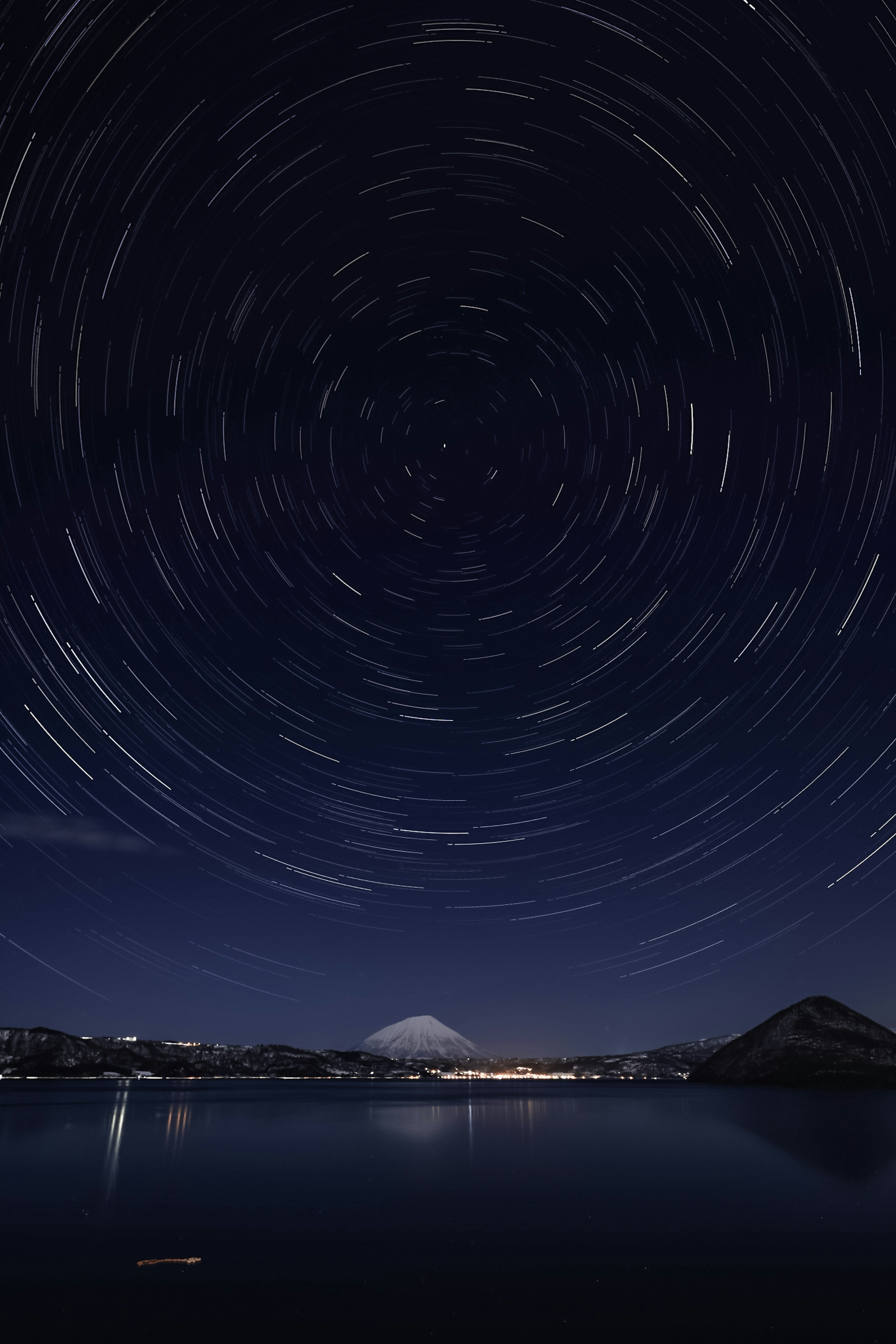 富士山と星の軌跡が映る夜空の風景