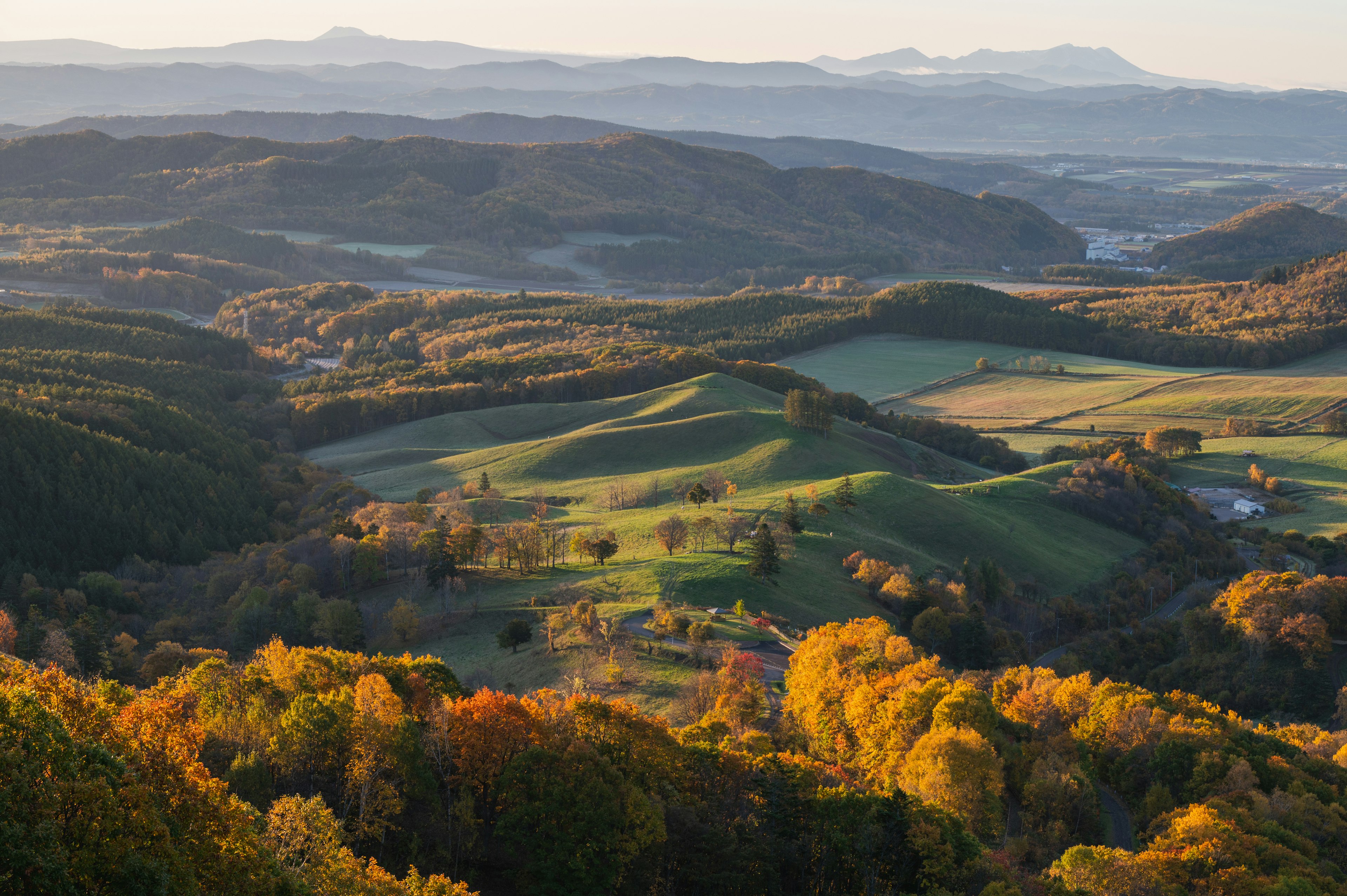 Scenic view of rolling hills in autumn colors with distant mountains and valleys