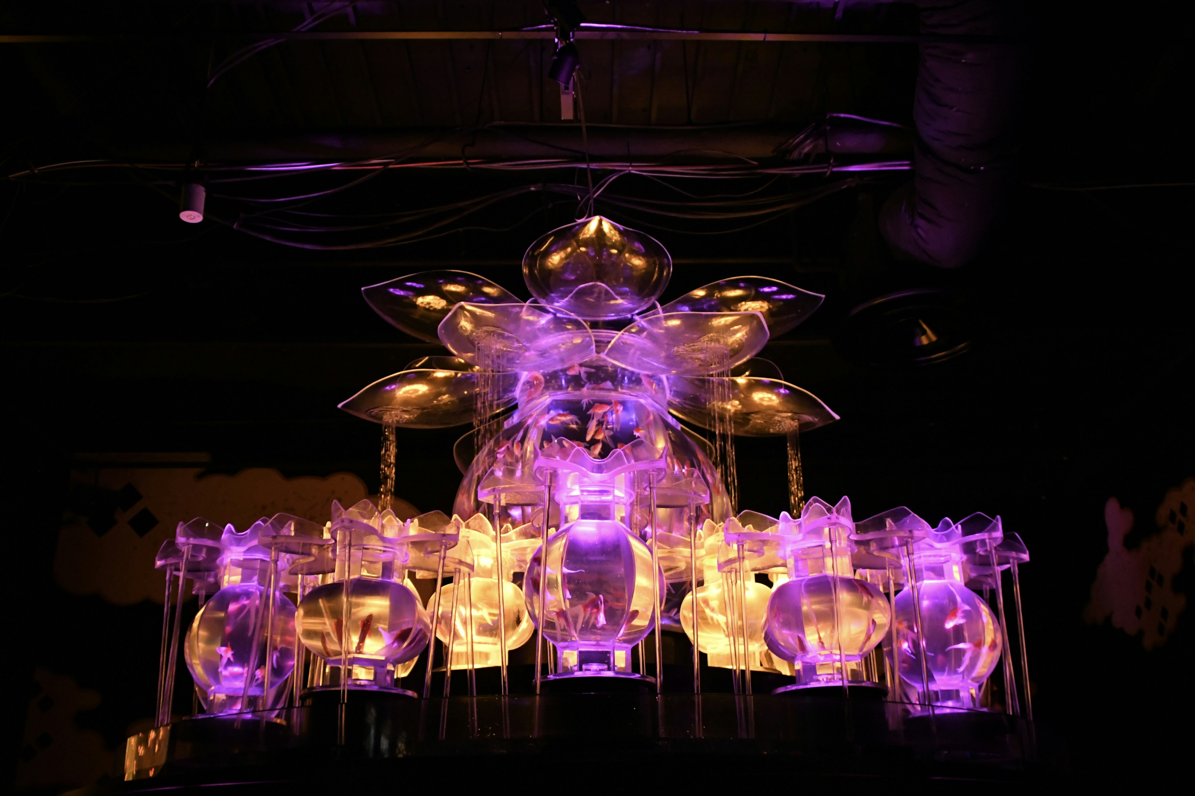 Chandelier unique émettant une lumière violette avec un design en verre transparent au centre