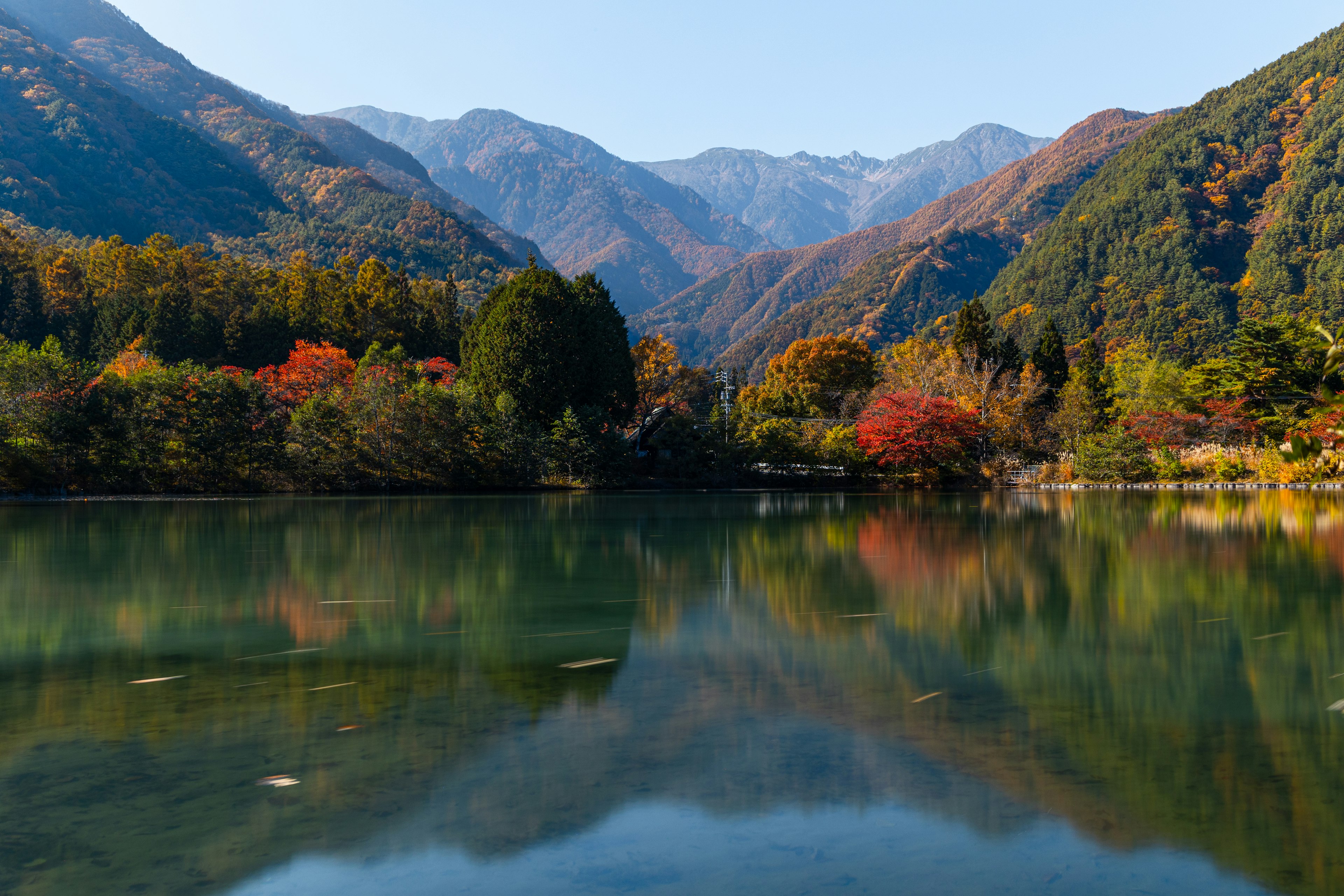 美しい山々と秋の紅葉が映る静かな湖