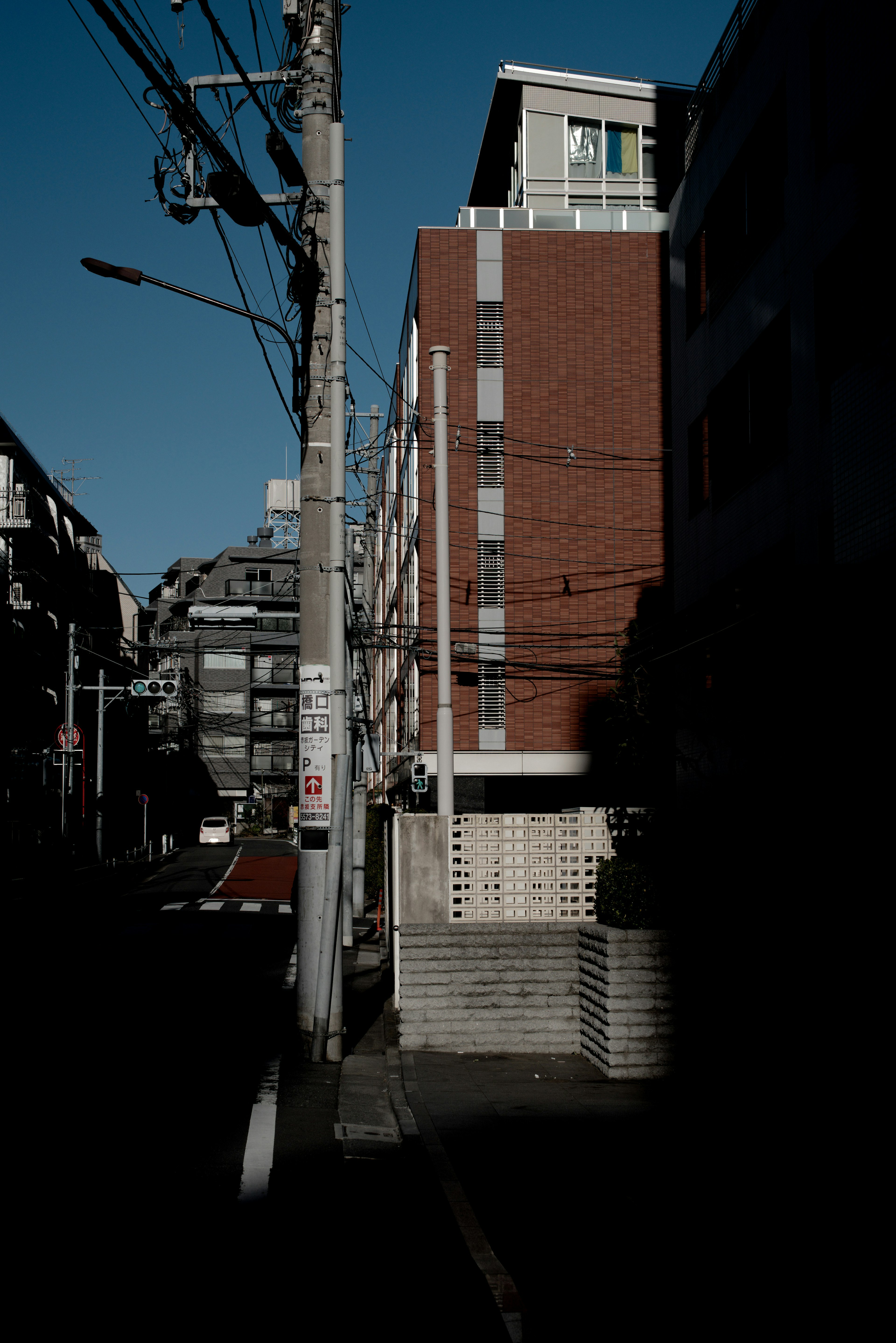 Edificio moderno en una calle oscura con postes de electricidad