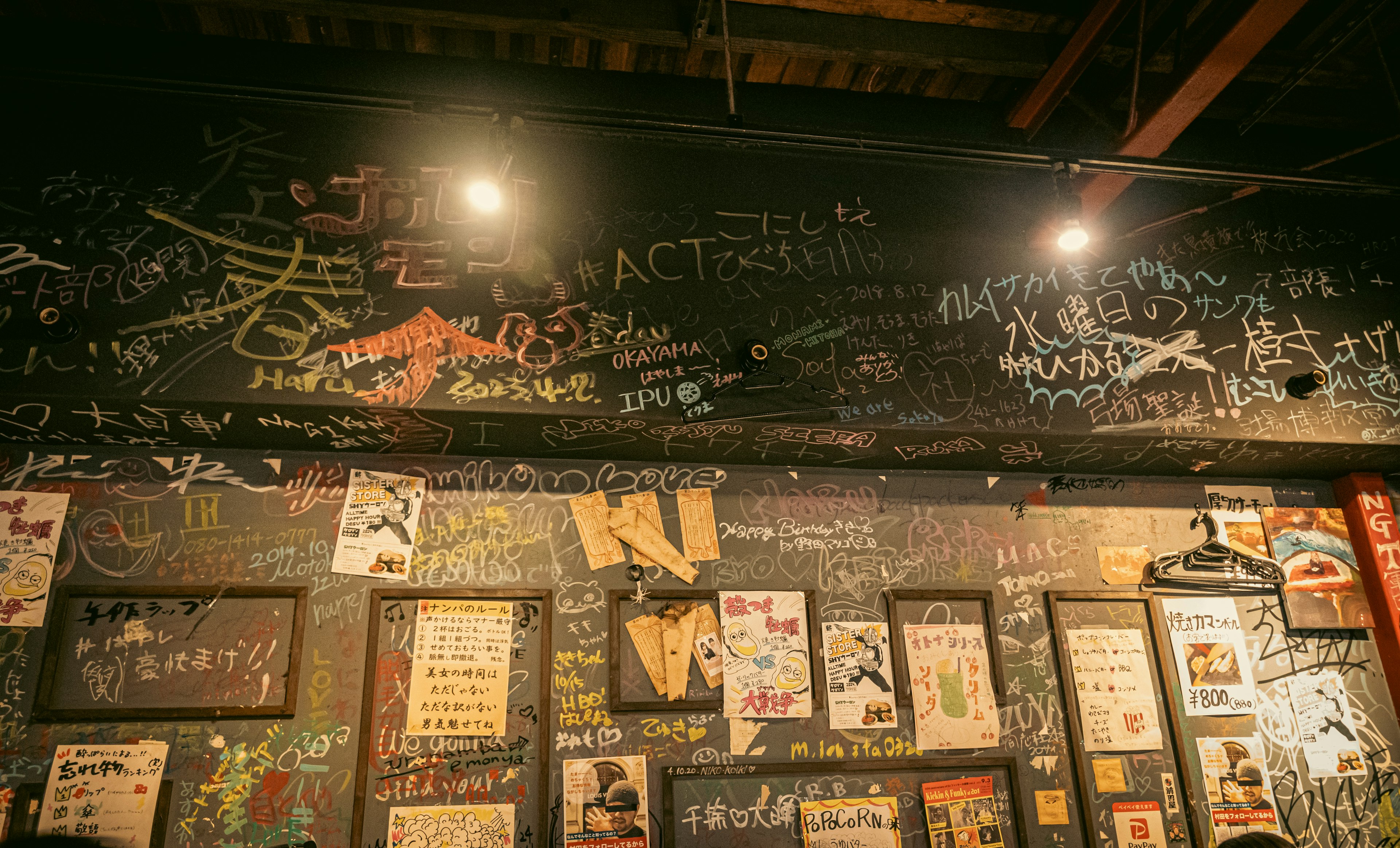 Wall covered with colorful chalk graffiti and vintage posters