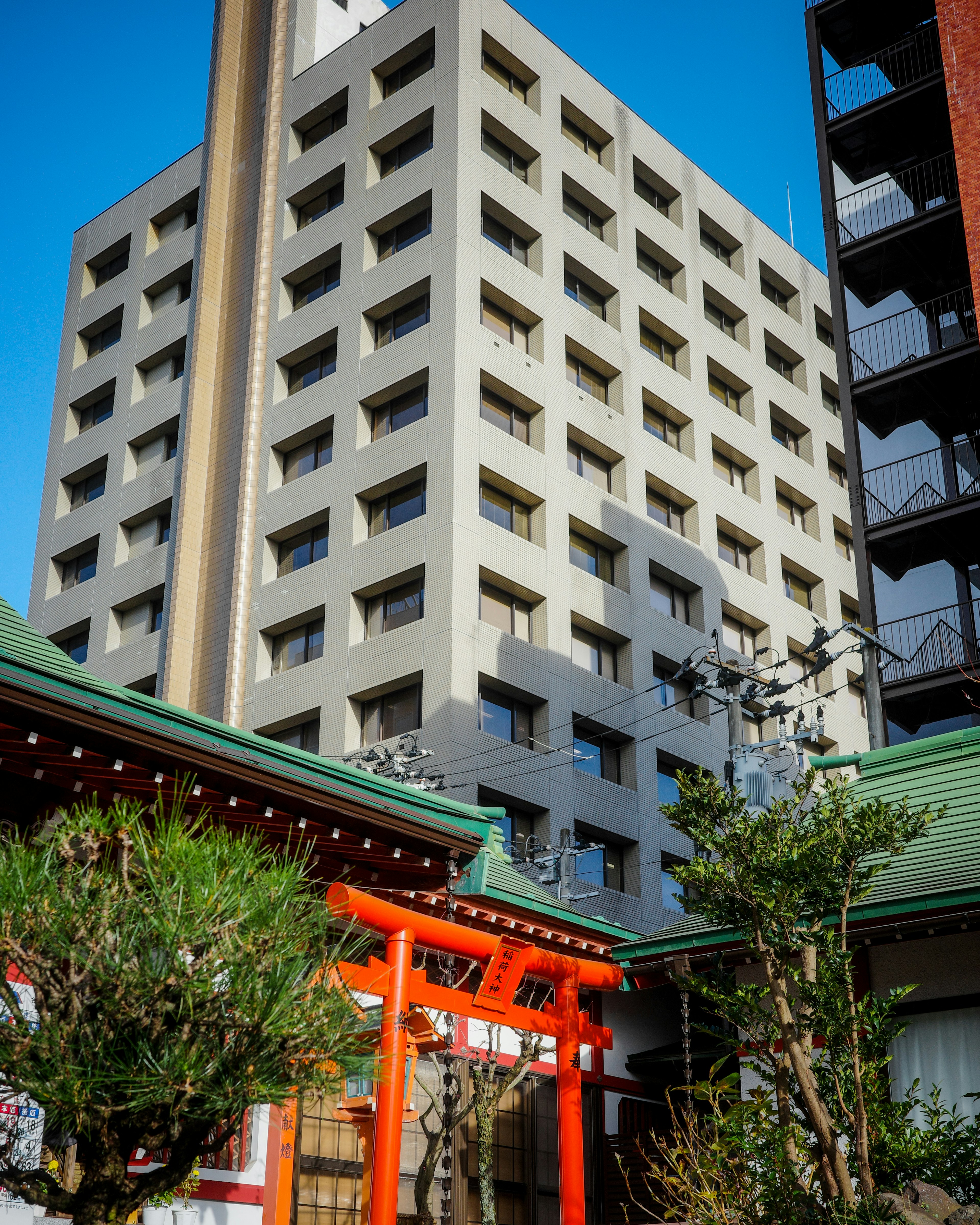 現代的な建物と伝統的な神社のコントラストがある風景