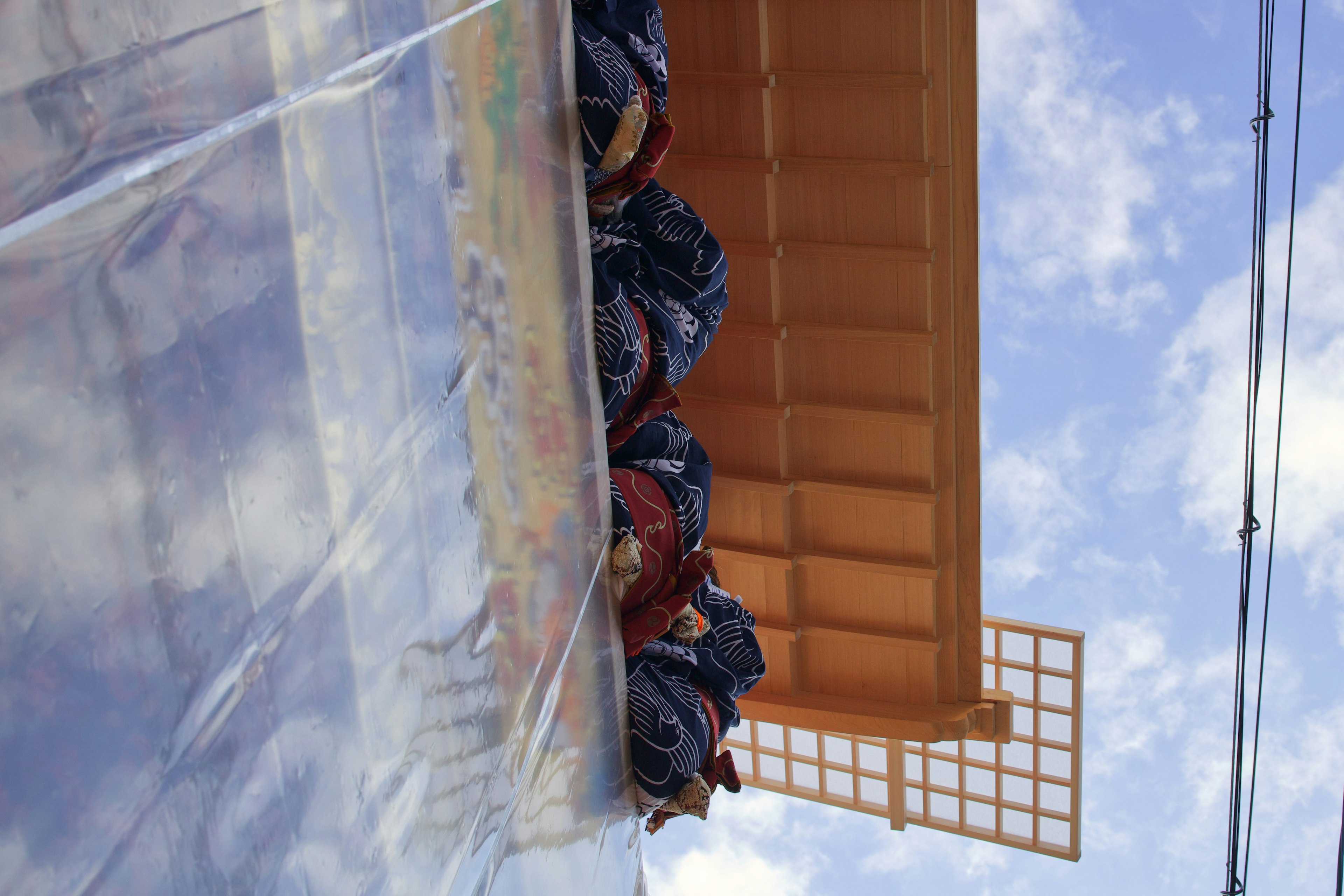 Bolsas de basura apiladas bajo un cielo azul claro con un techo naranja