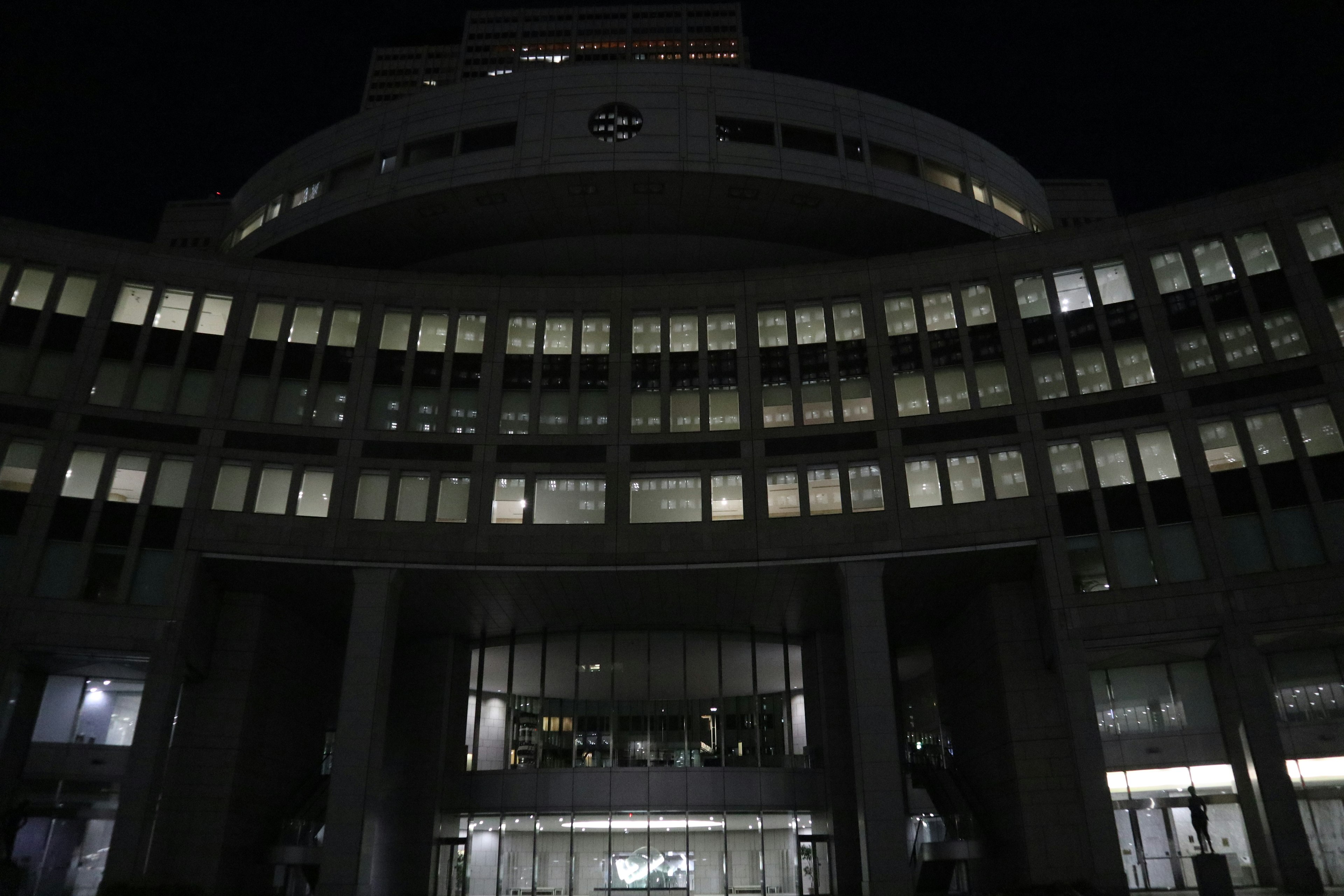 Vista esterna di un edificio cittadino di notte con finestre illuminate