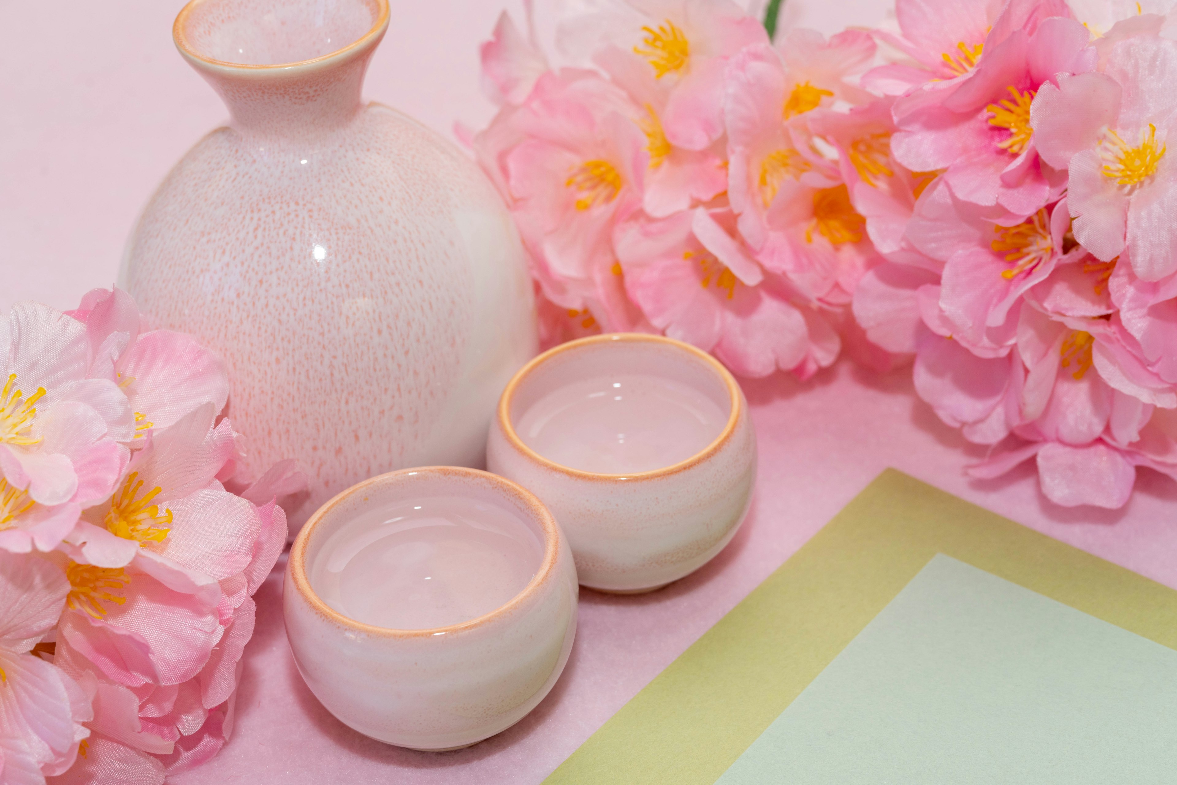 Bella disposizione della tavola con fiori rosa e recipienti in ceramica