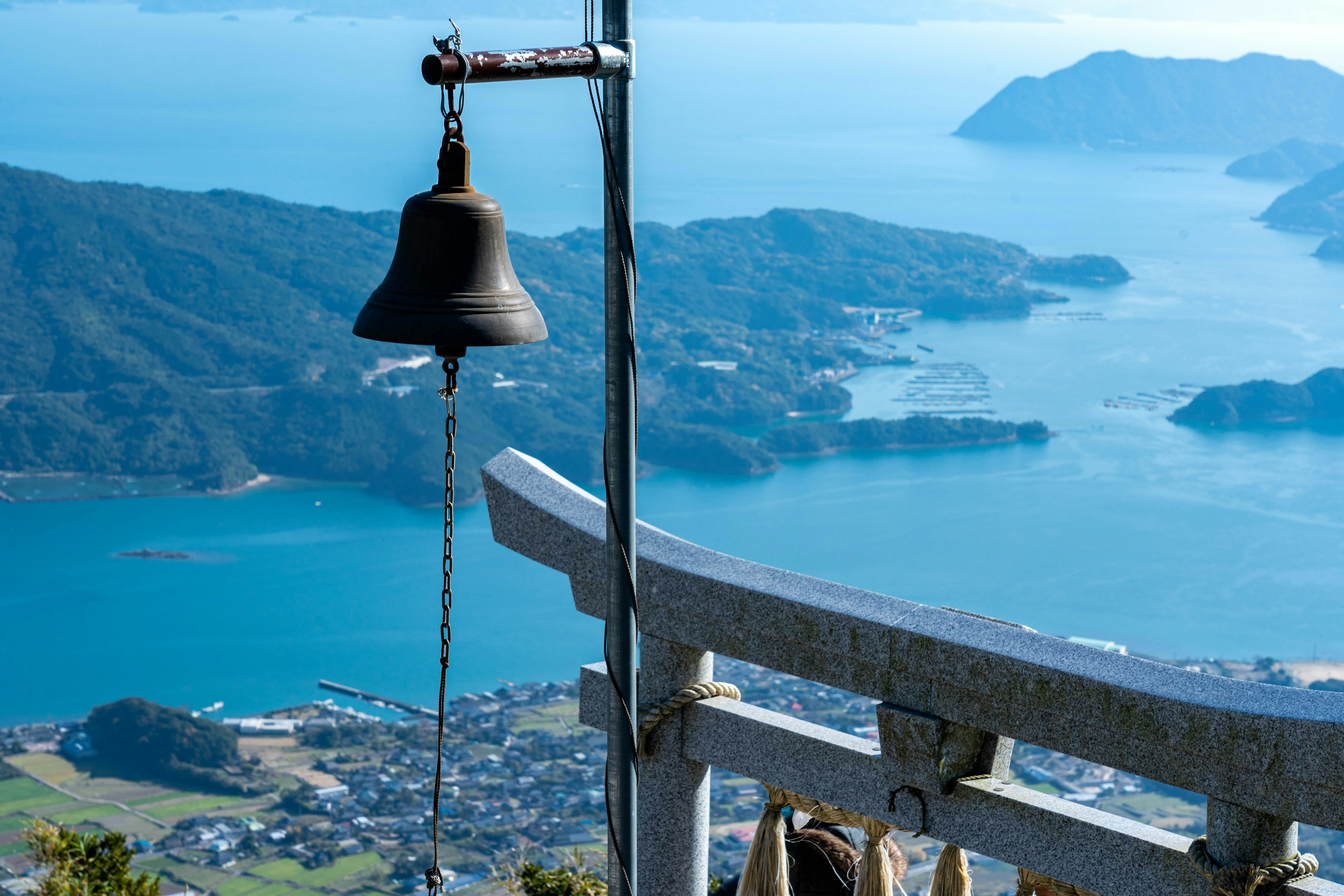 Bell on a mountain top overlooking a blue sea