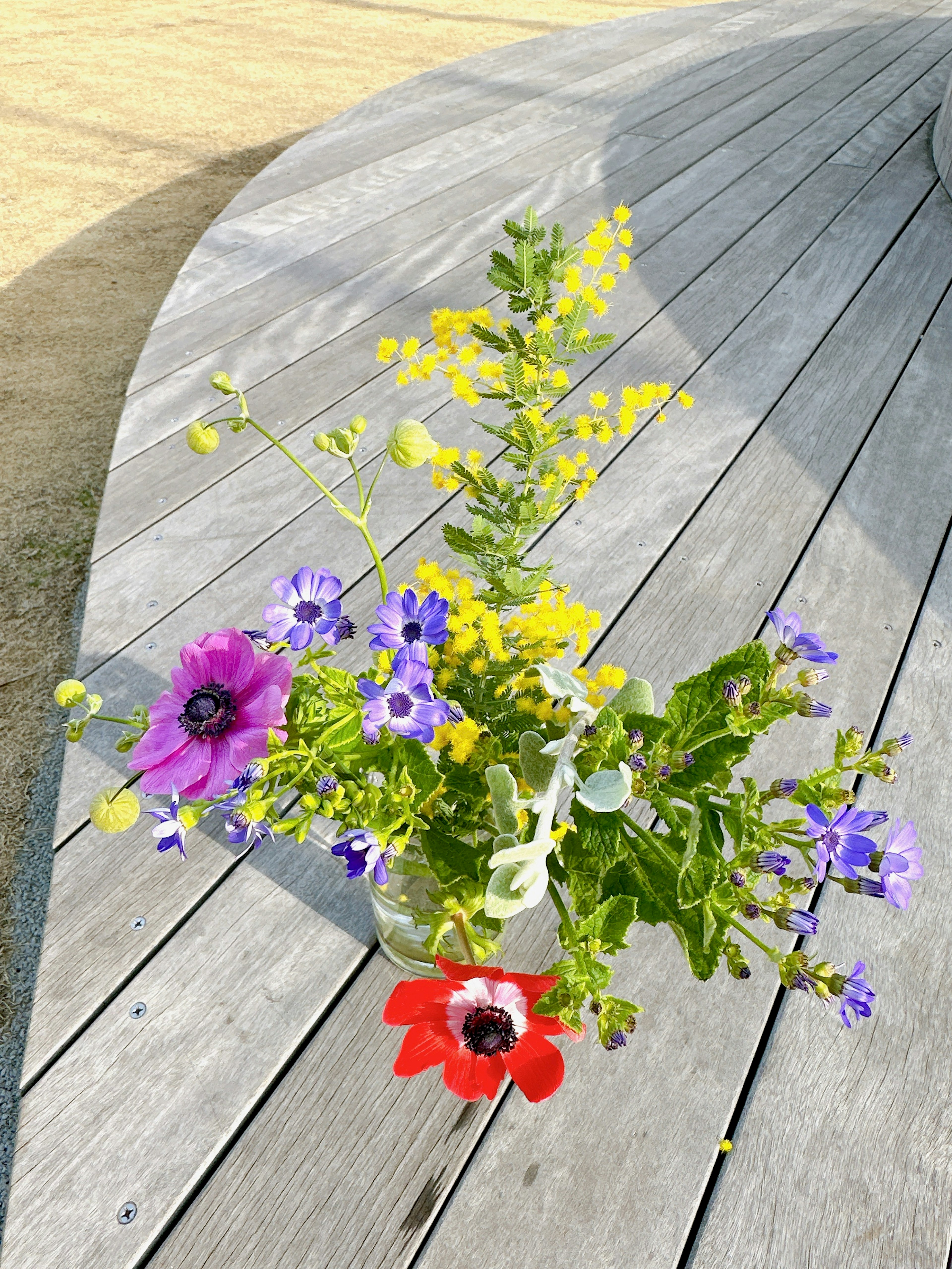 Un jarrón de flores coloridas sobre una mesa de madera