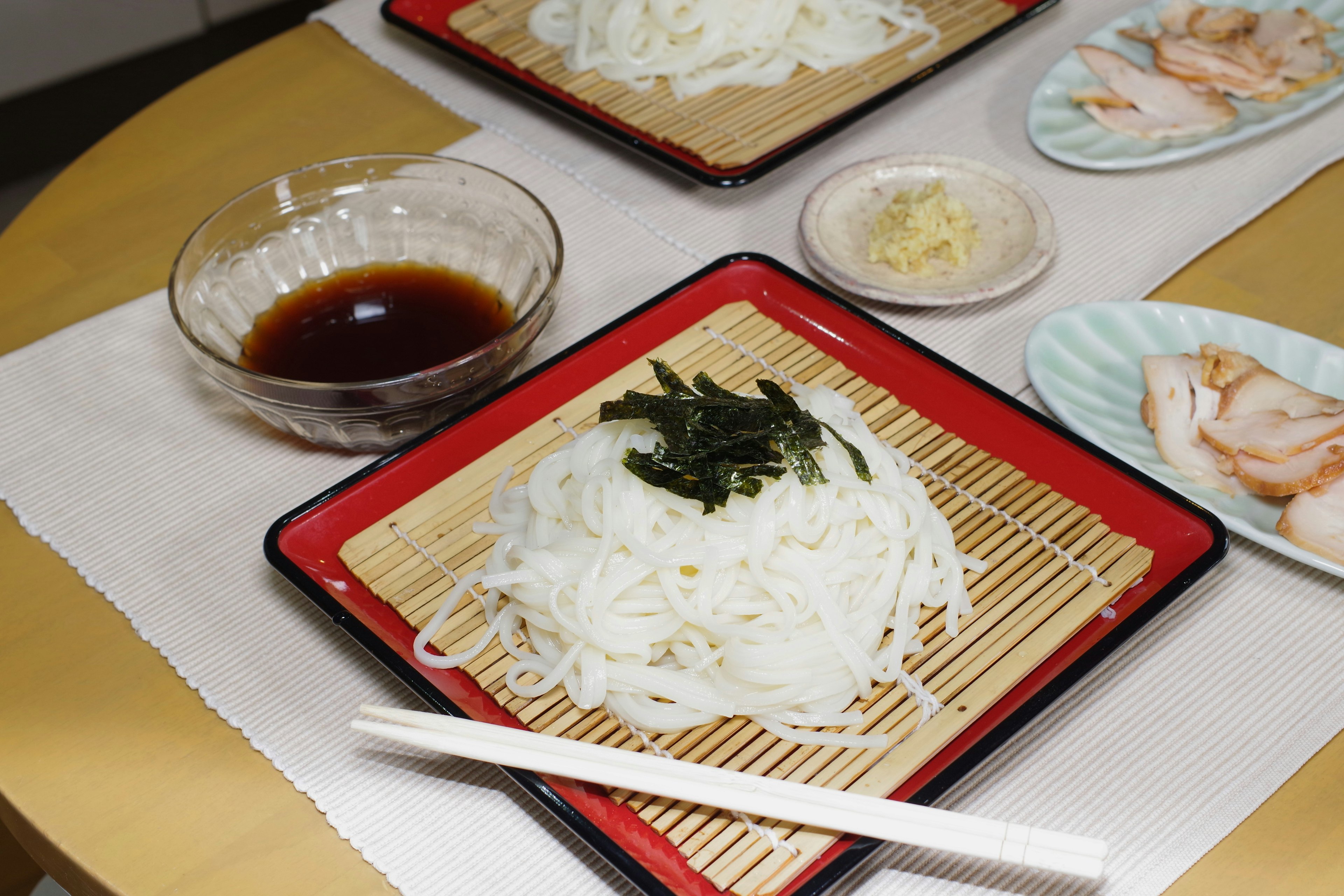 A dish of white noodles topped with seaweed served on a traditional plate