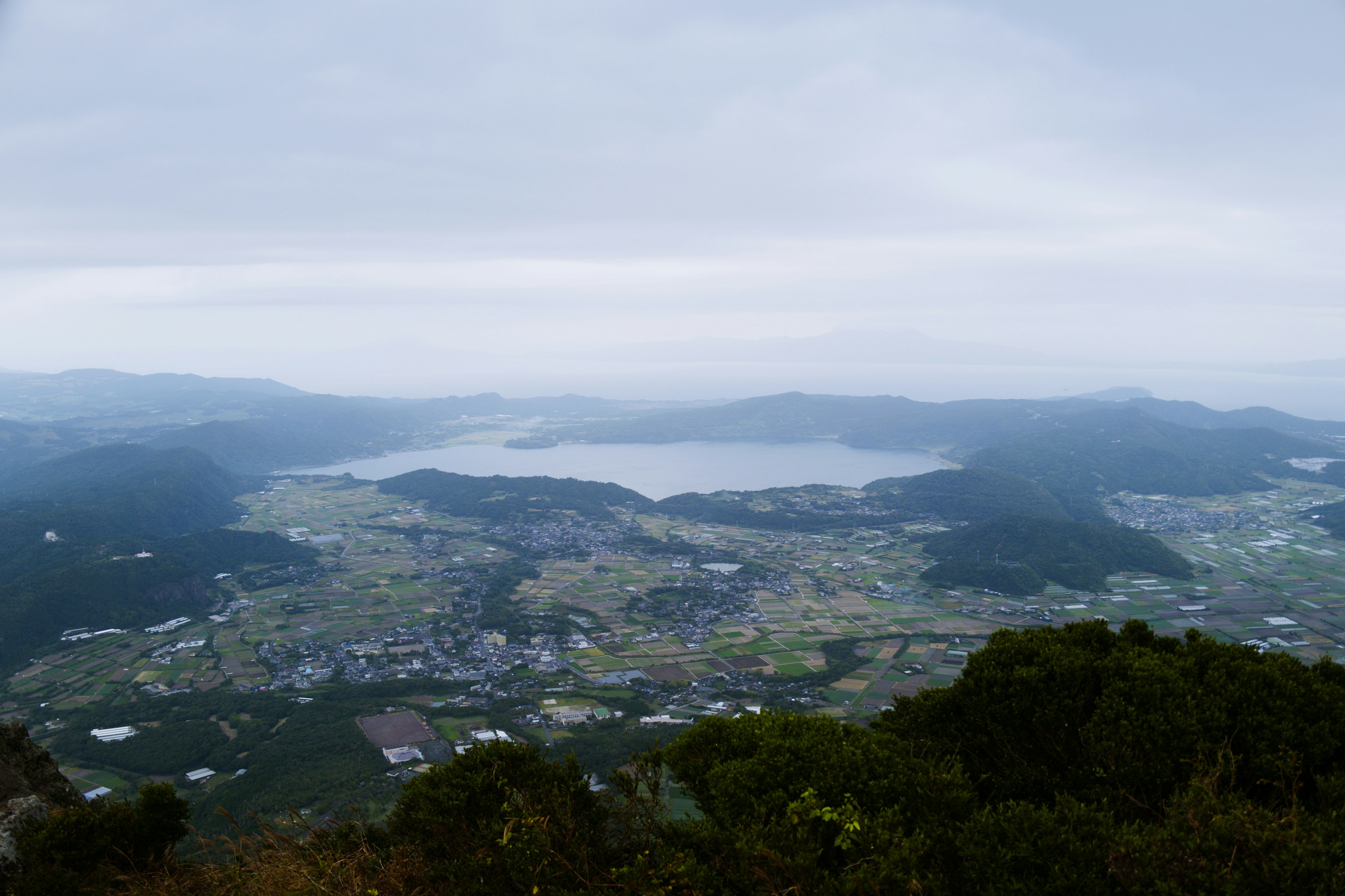 Une vue panoramique depuis le sommet d'une montagne avec un lac et des champs verdoyants