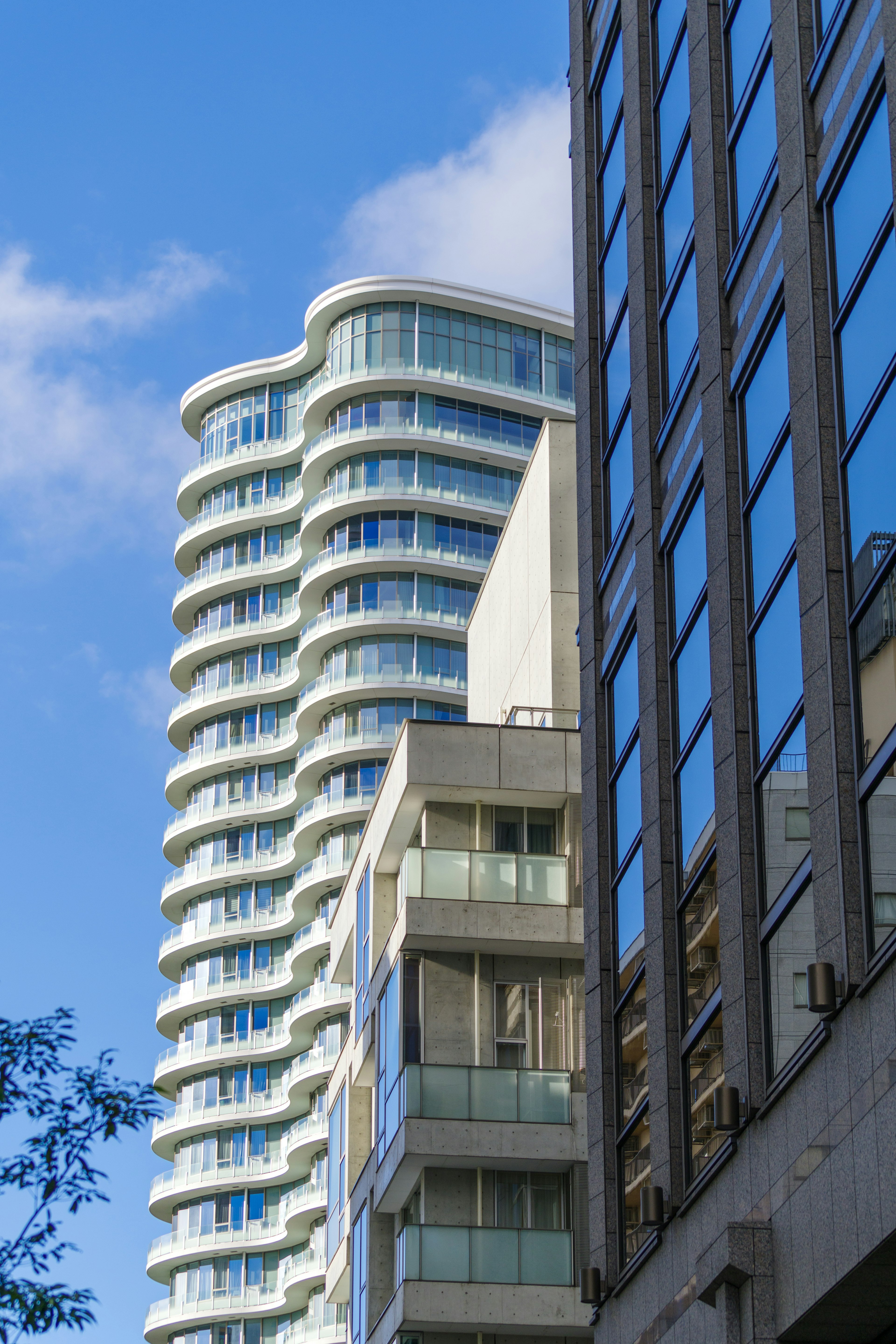 Fachada de un edificio moderno con diseño curvo bajo un cielo azul claro