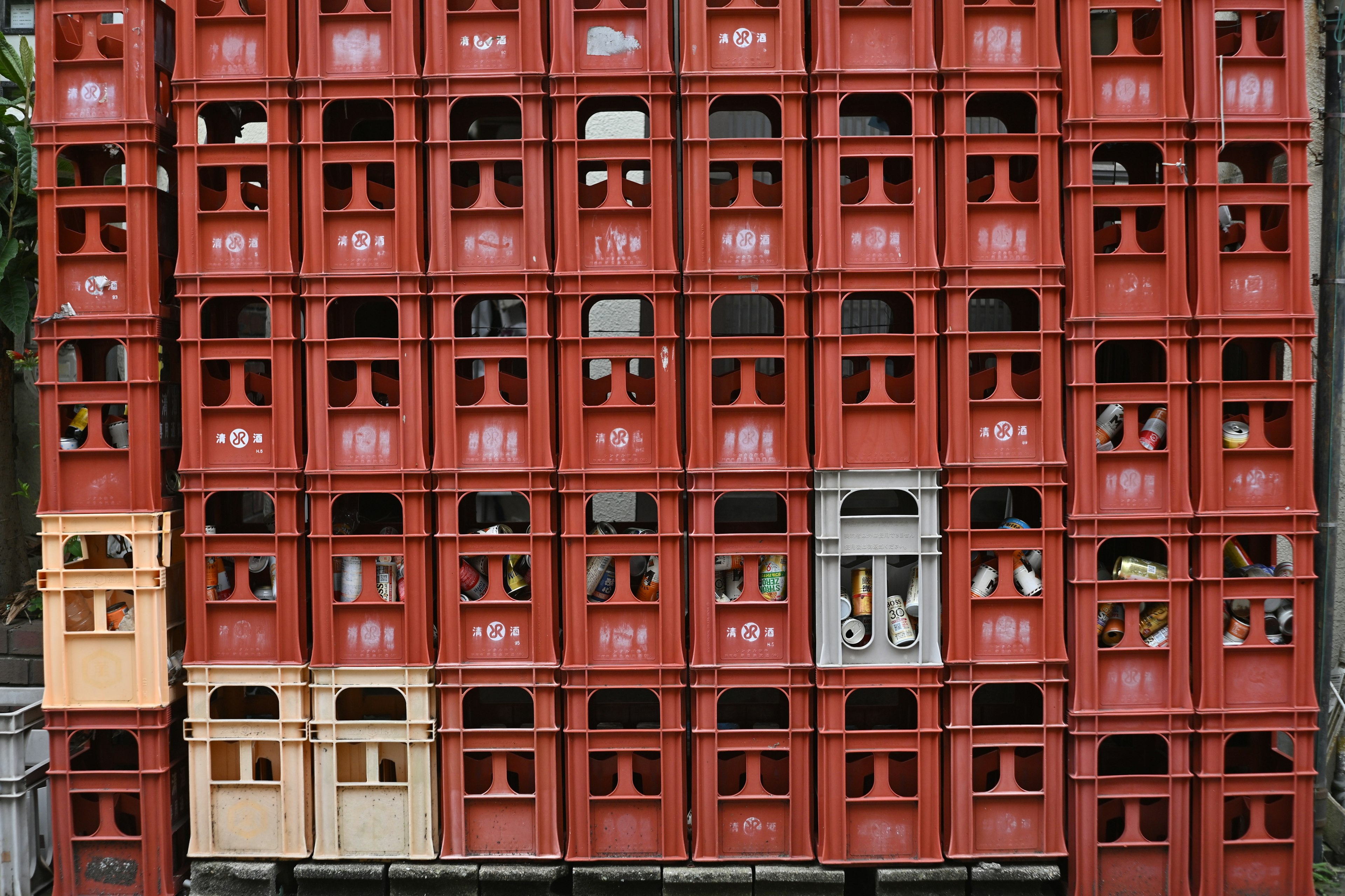 Cajas de cerveza rojas apiladas con algunas cajas de colores diferentes que destacan