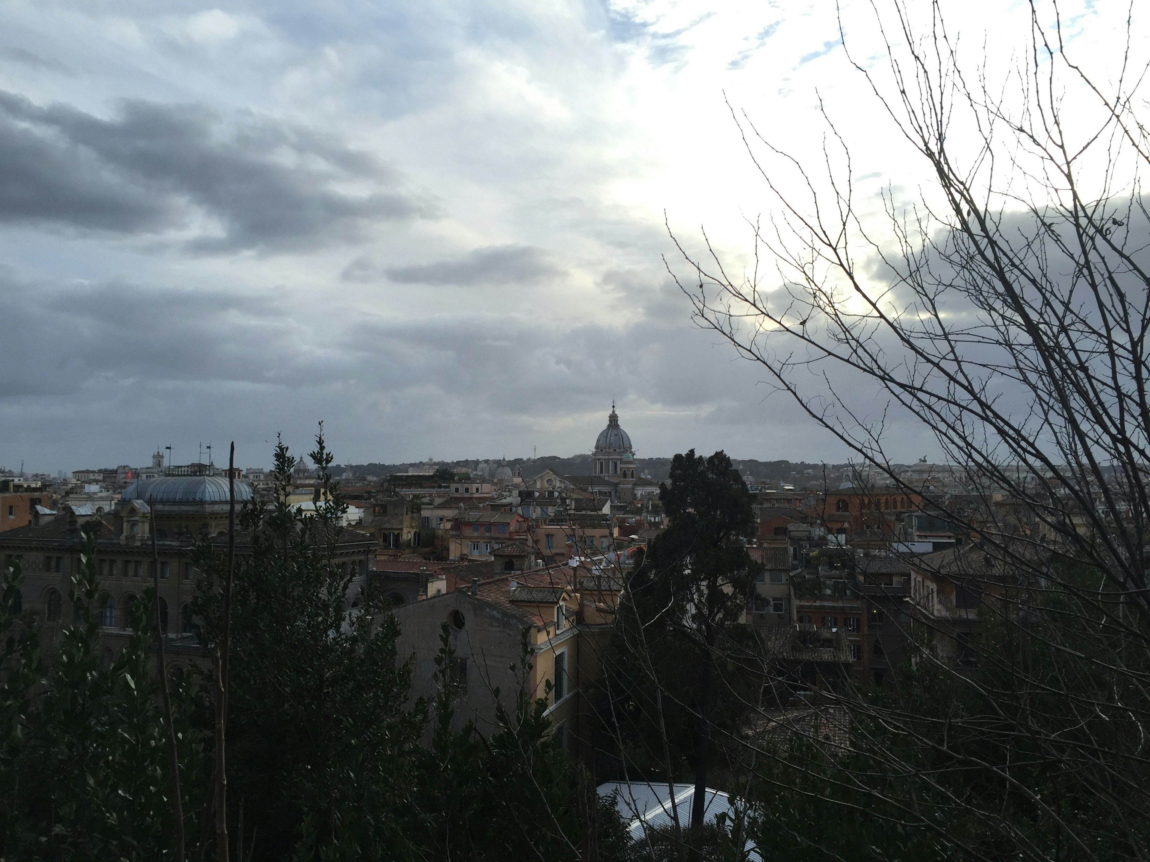 Vista sullo skyline di Roma con cupola di chiesa e cielo nuvoloso