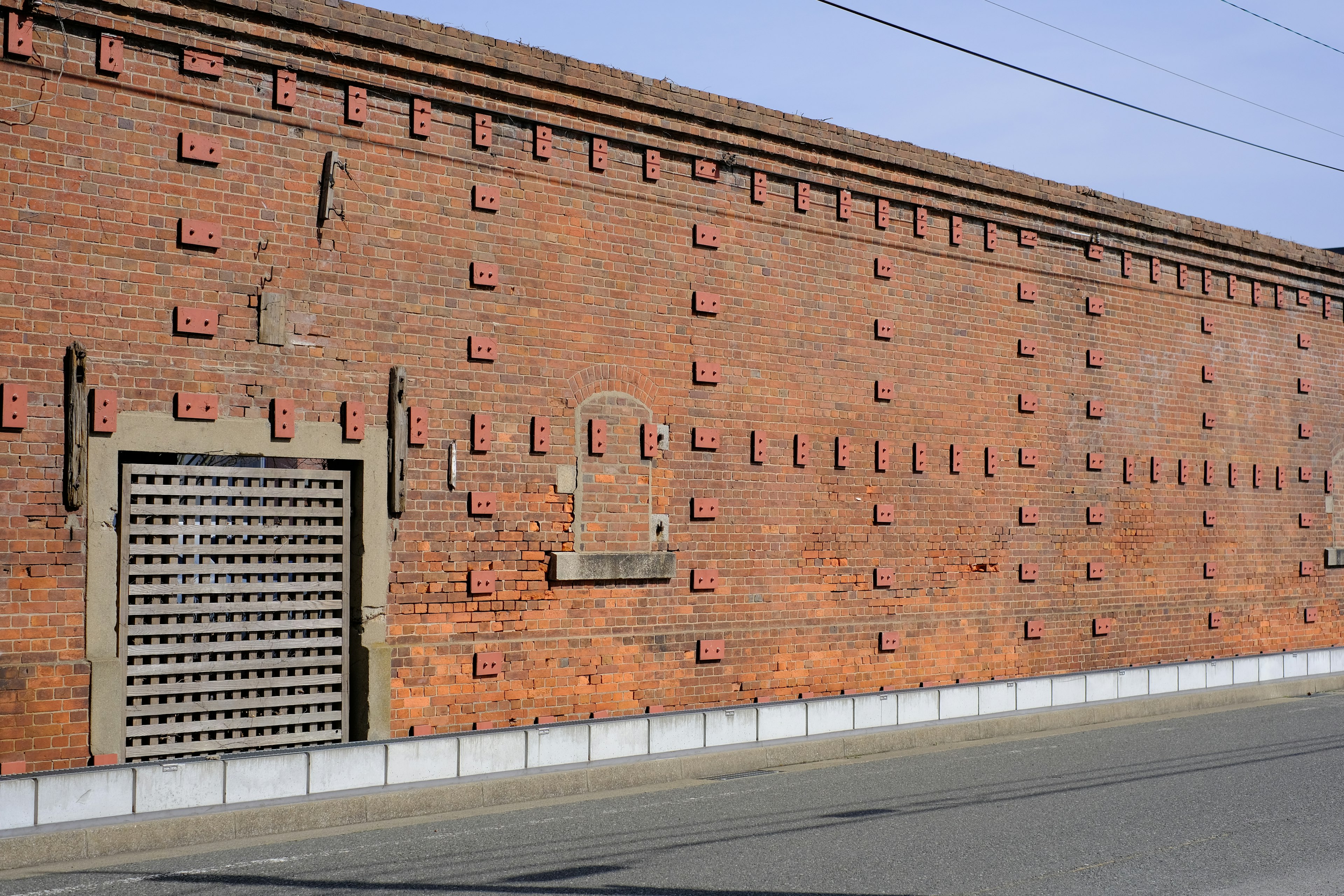 Vue extérieure d'un mur en briques avec une porte en métal