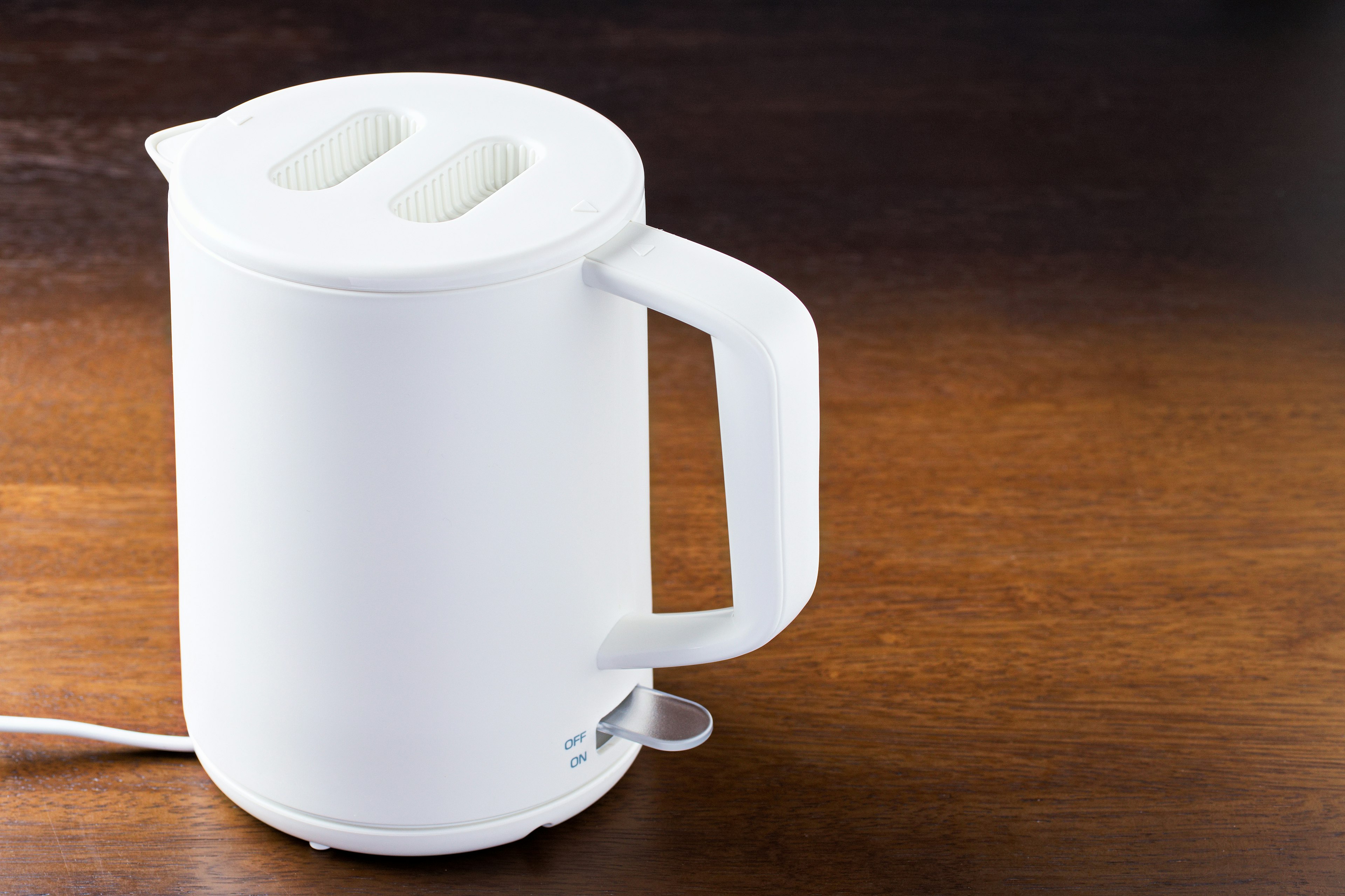 White electric kettle placed on a wooden table