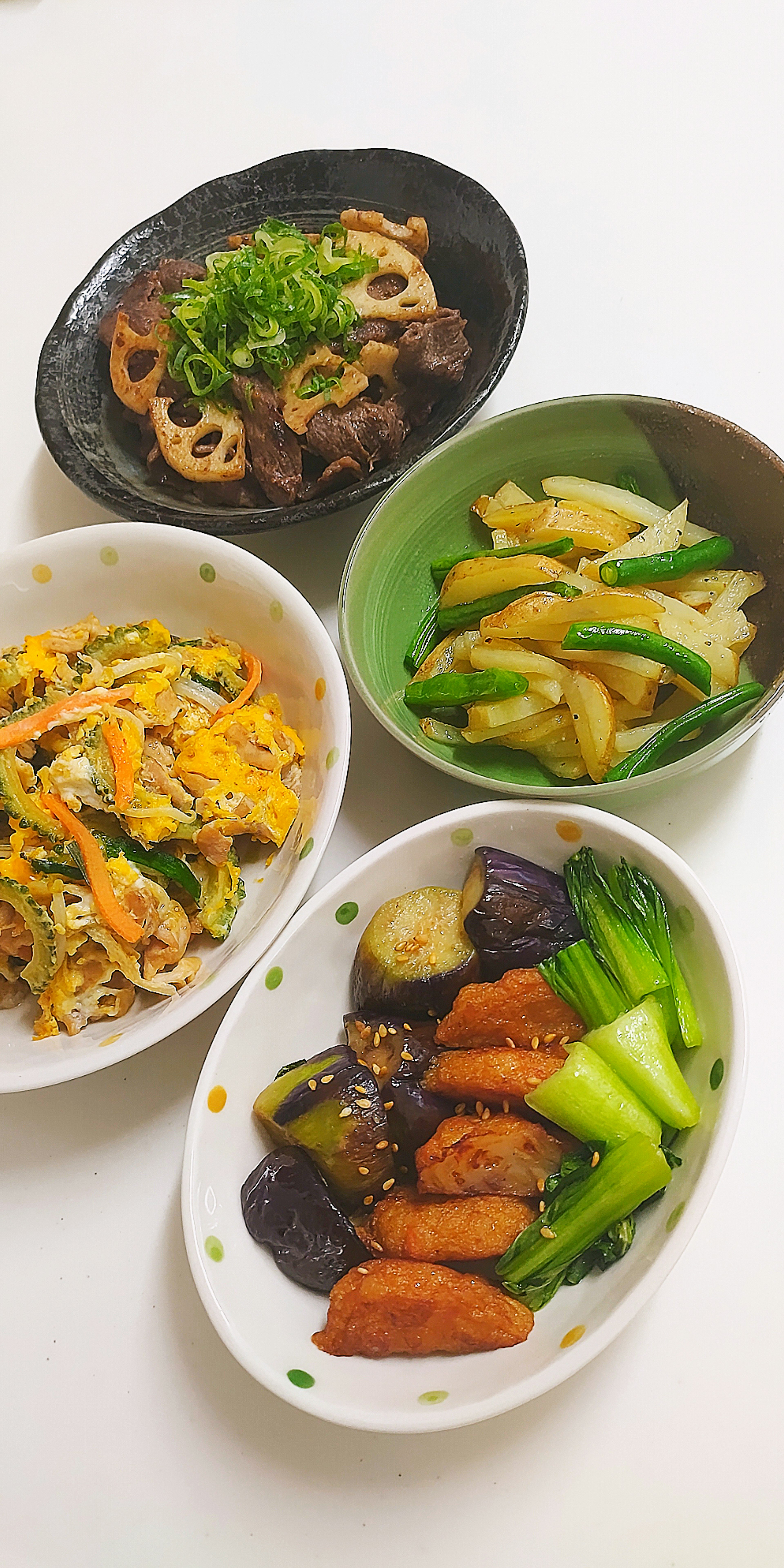 Colorful assortment of Japanese dishes featuring simmered vegetables and stir-fried items