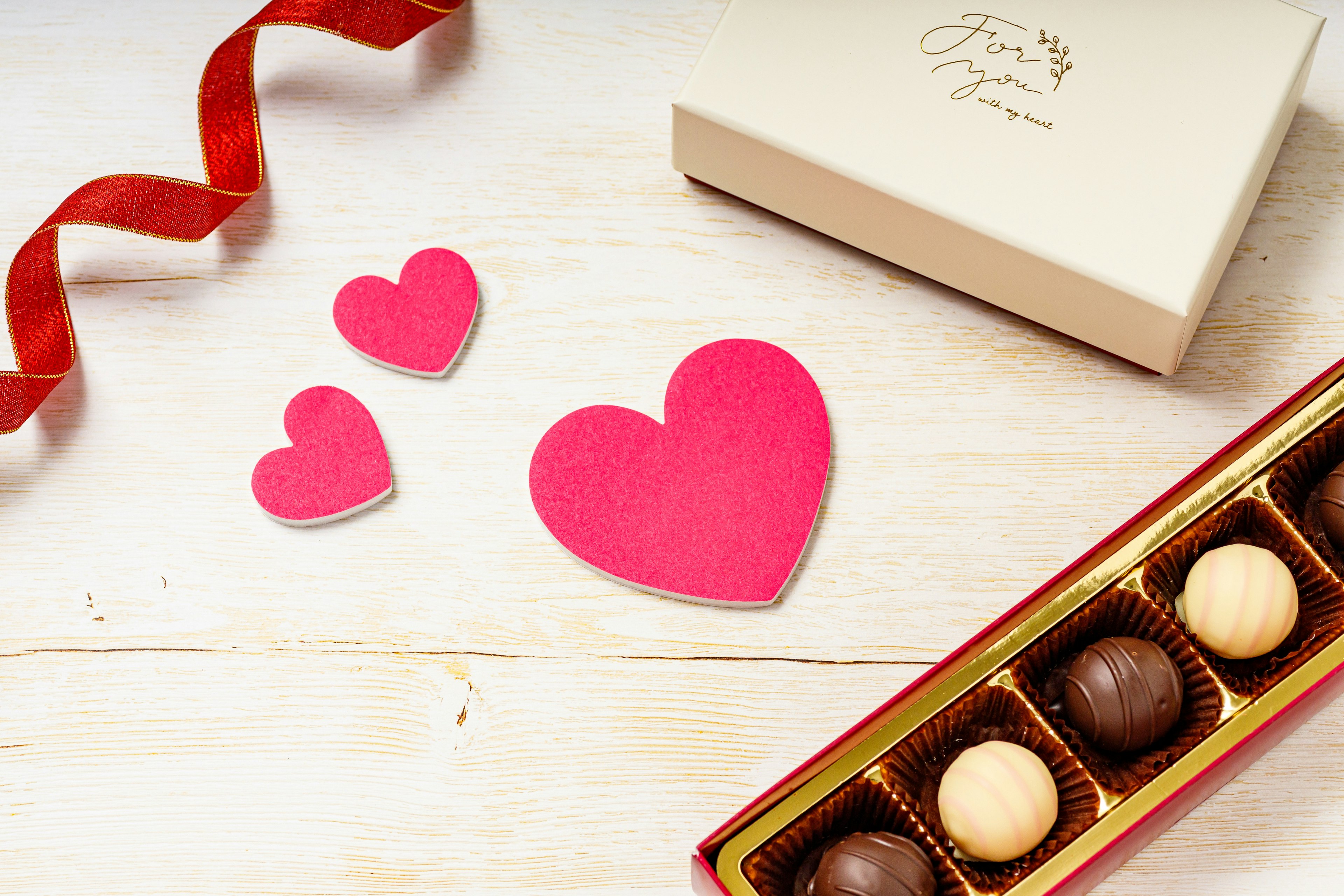 Décorations en forme de cœur rouges et une boîte de chocolats assortis