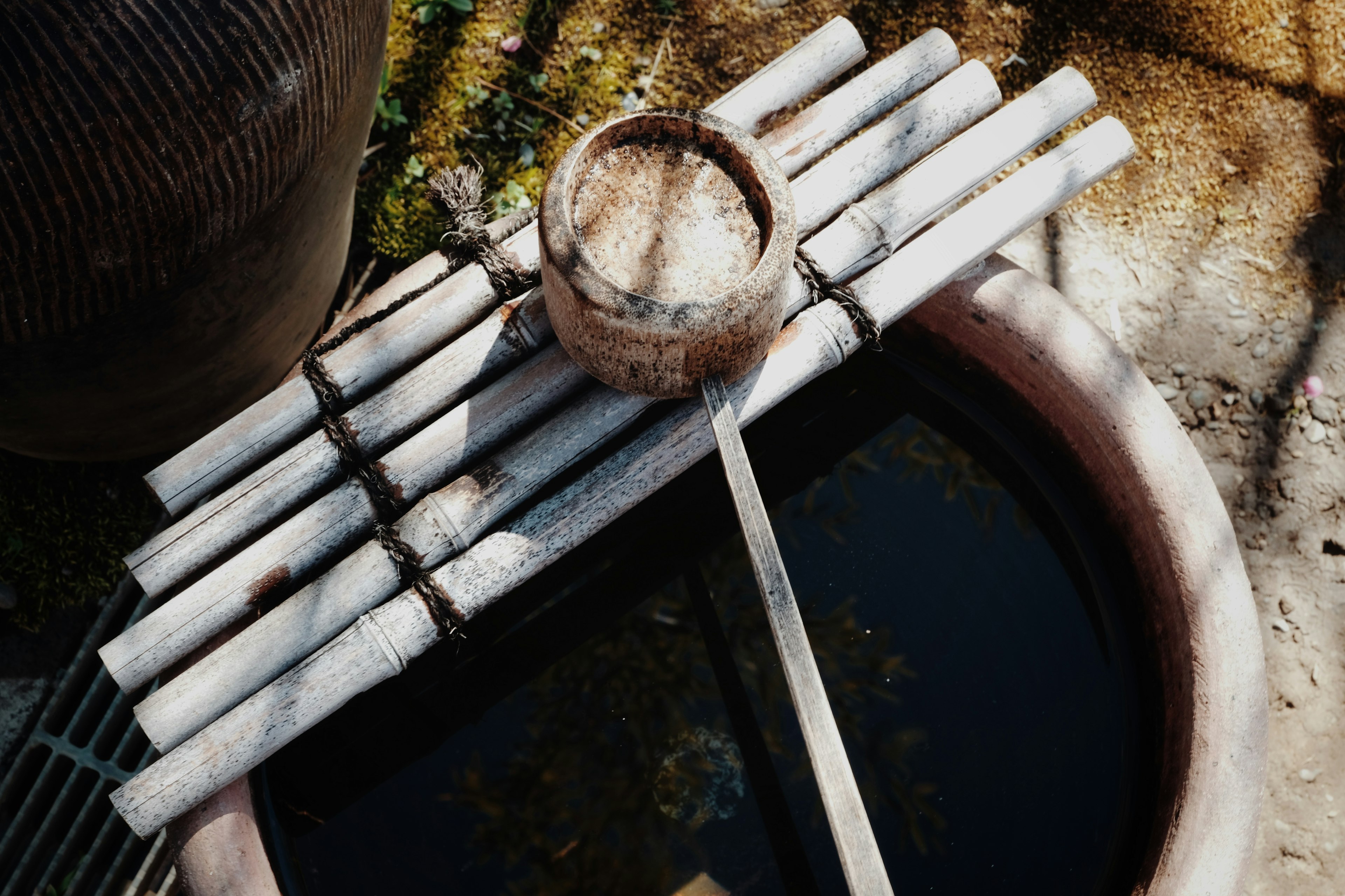 Scène d'un puits avec un seau d'eau et des bâtons de bambou