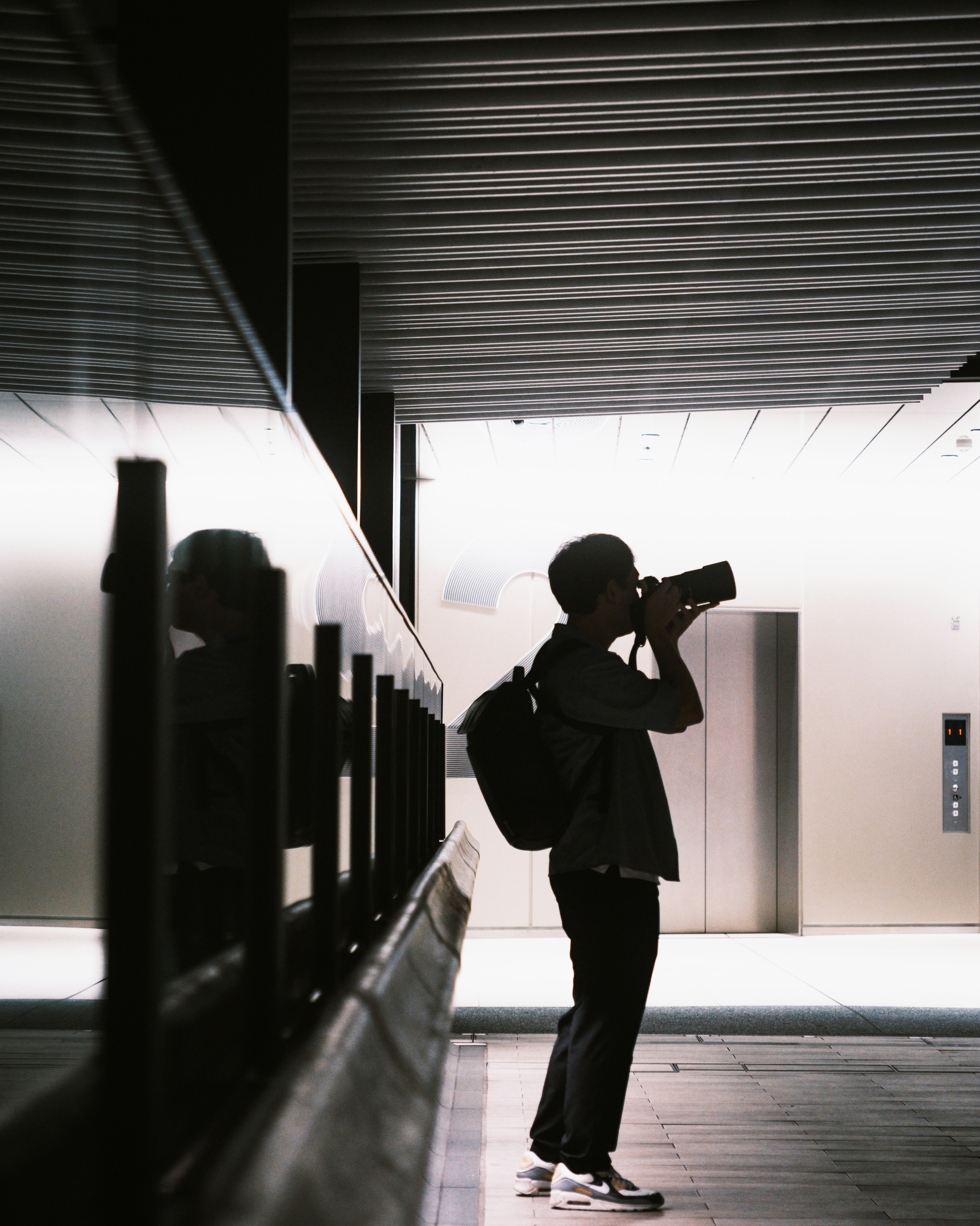 Silhouette di un uomo con uno zaino che scatta una foto con una macchina fotografica