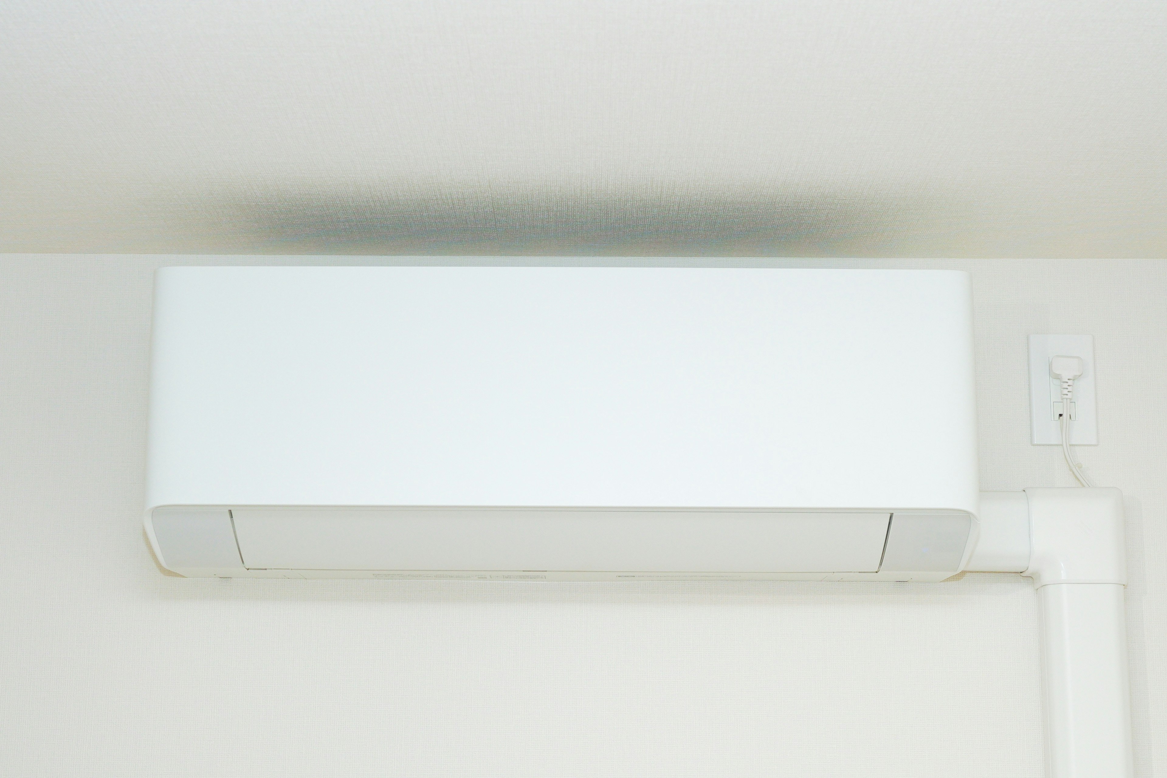 A white air conditioner mounted on the ceiling