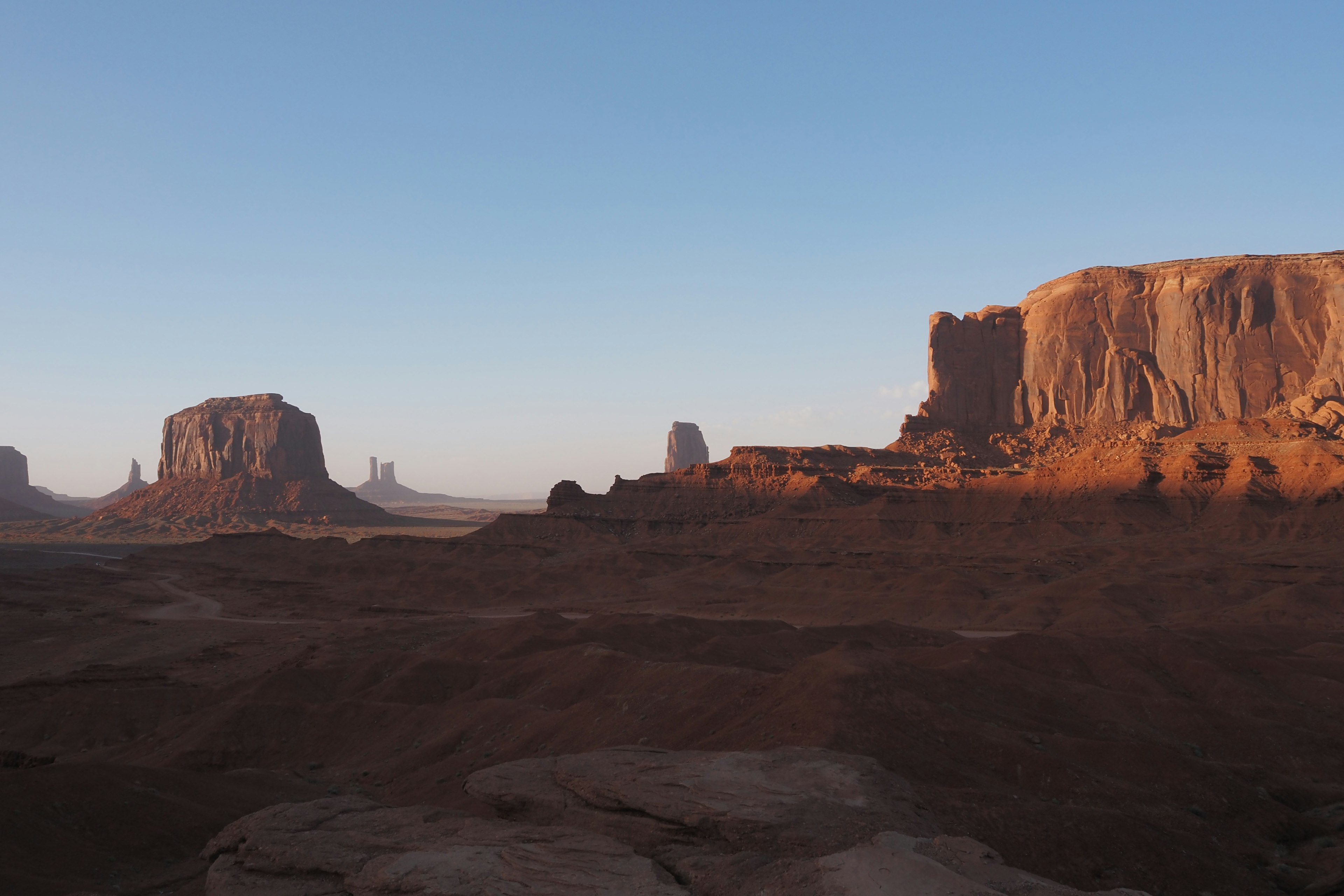 Impresionante paisaje de Monument Valley con formaciones rocosas rojas bajo un cielo azul claro