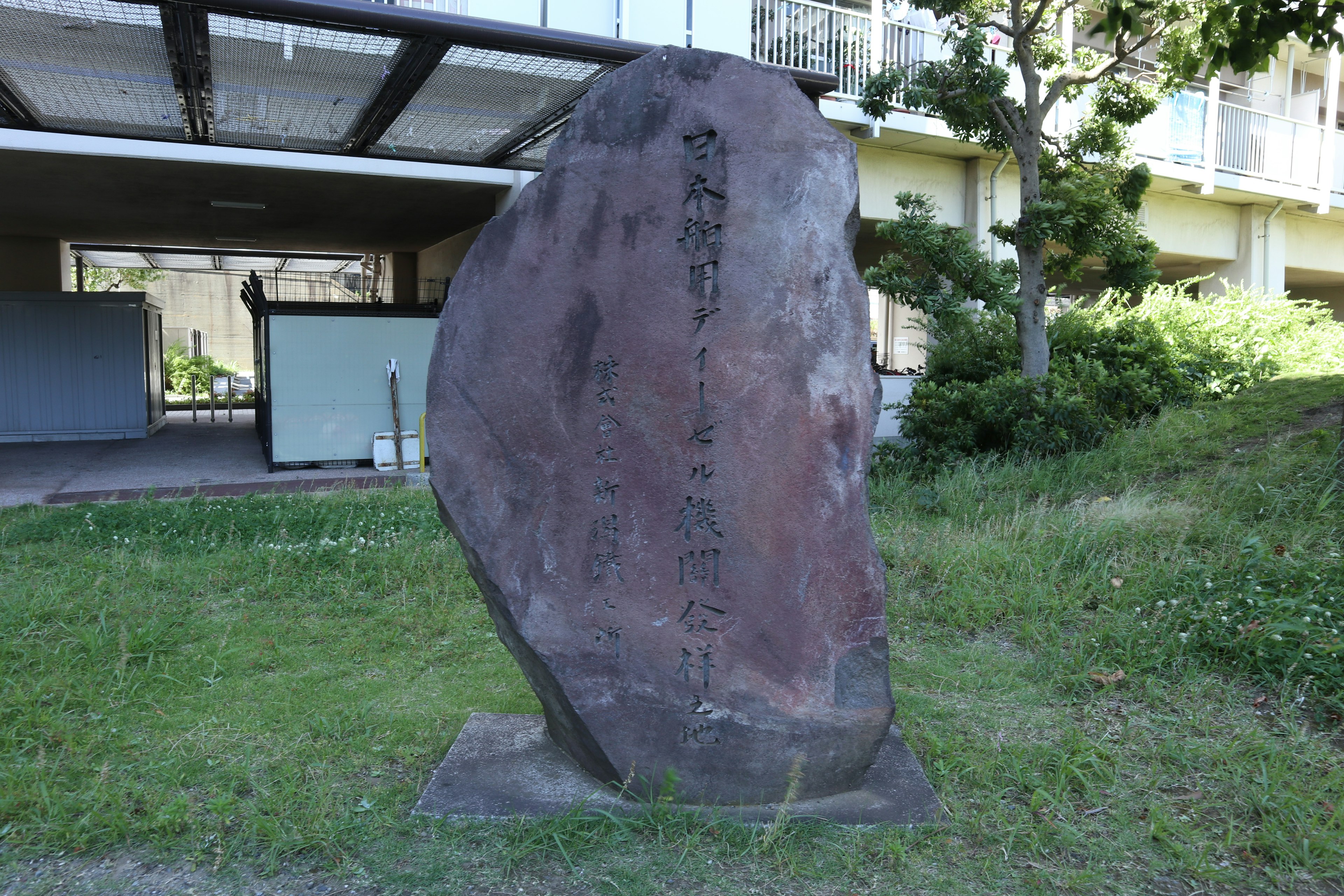 Große Steinskulptur in einem Park umgeben von grünem Gras und Bäumen