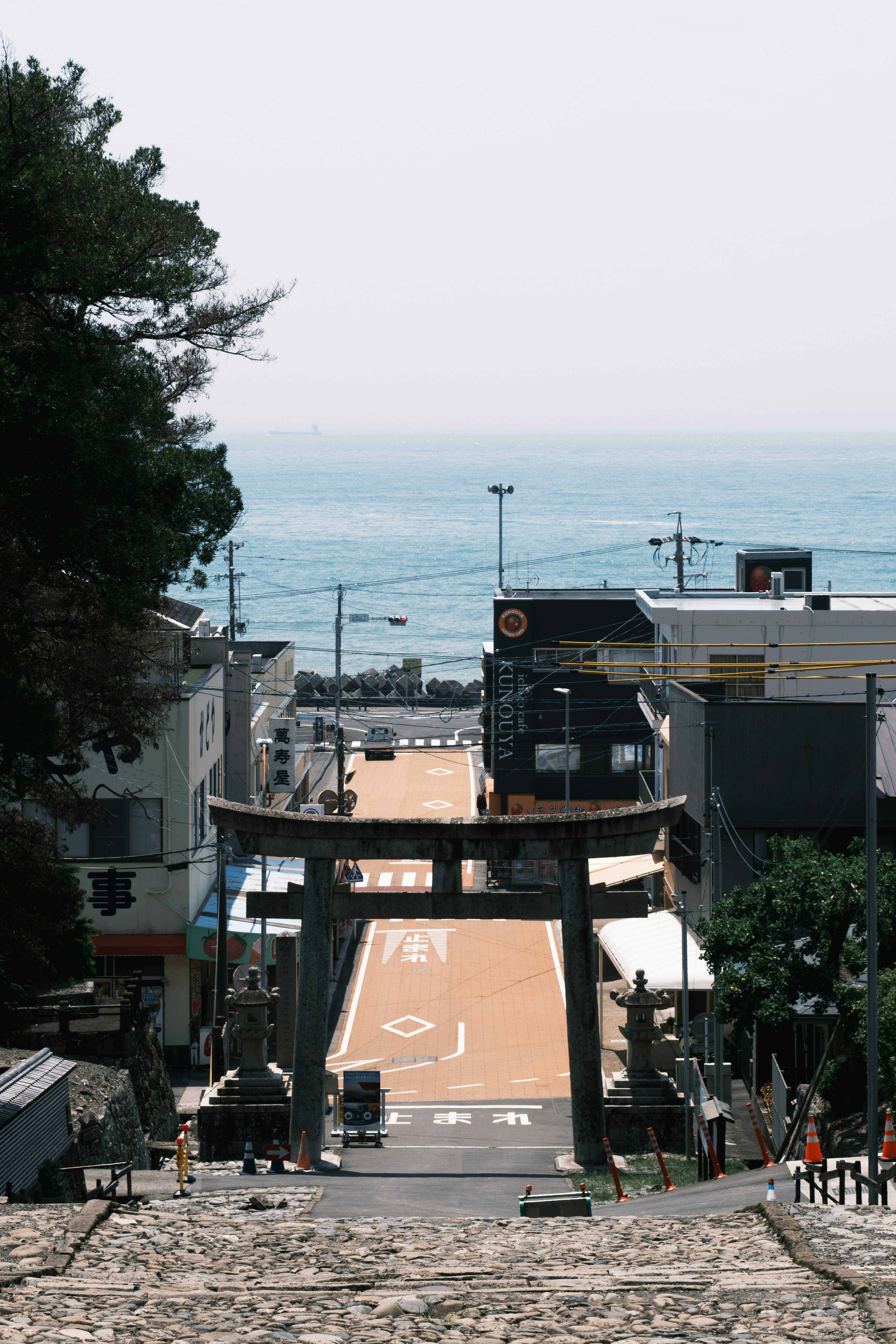 海に面した街の風景と鳥居のある道