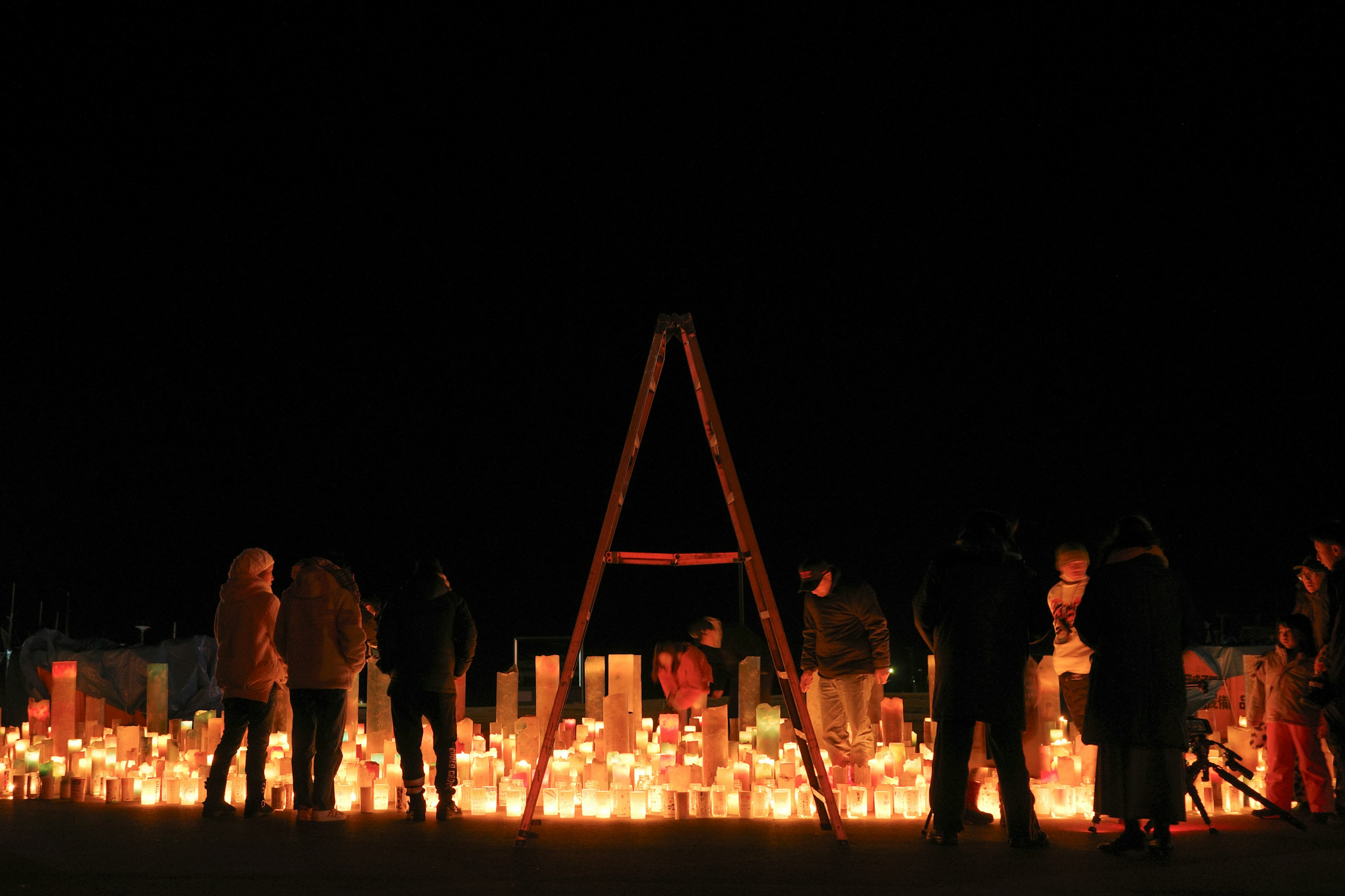 Personas reunidas alrededor de una ceremonia de velas por la noche