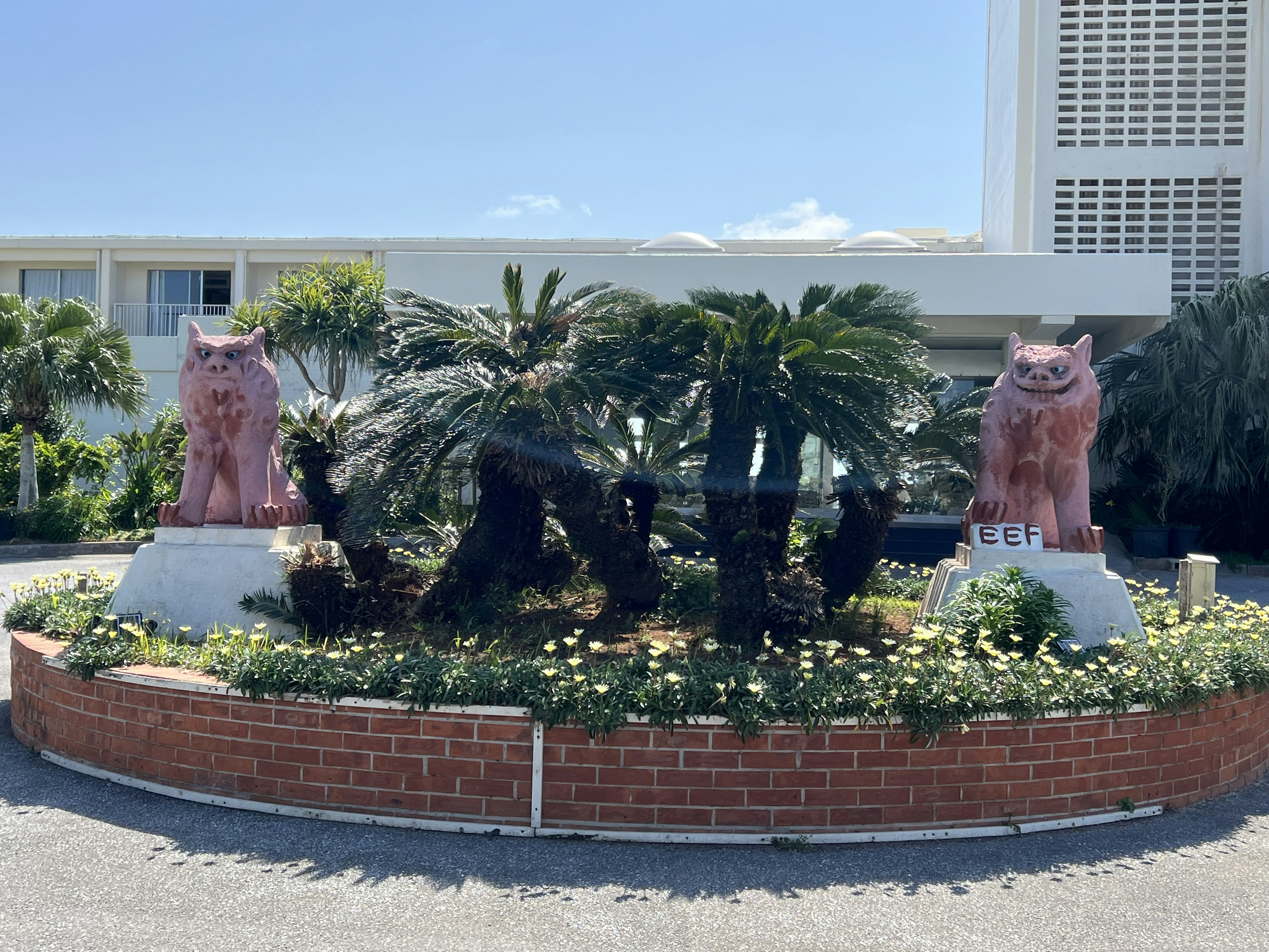 Landschaft mit rosa Löwenstatuen umgeben von üppigem Grün