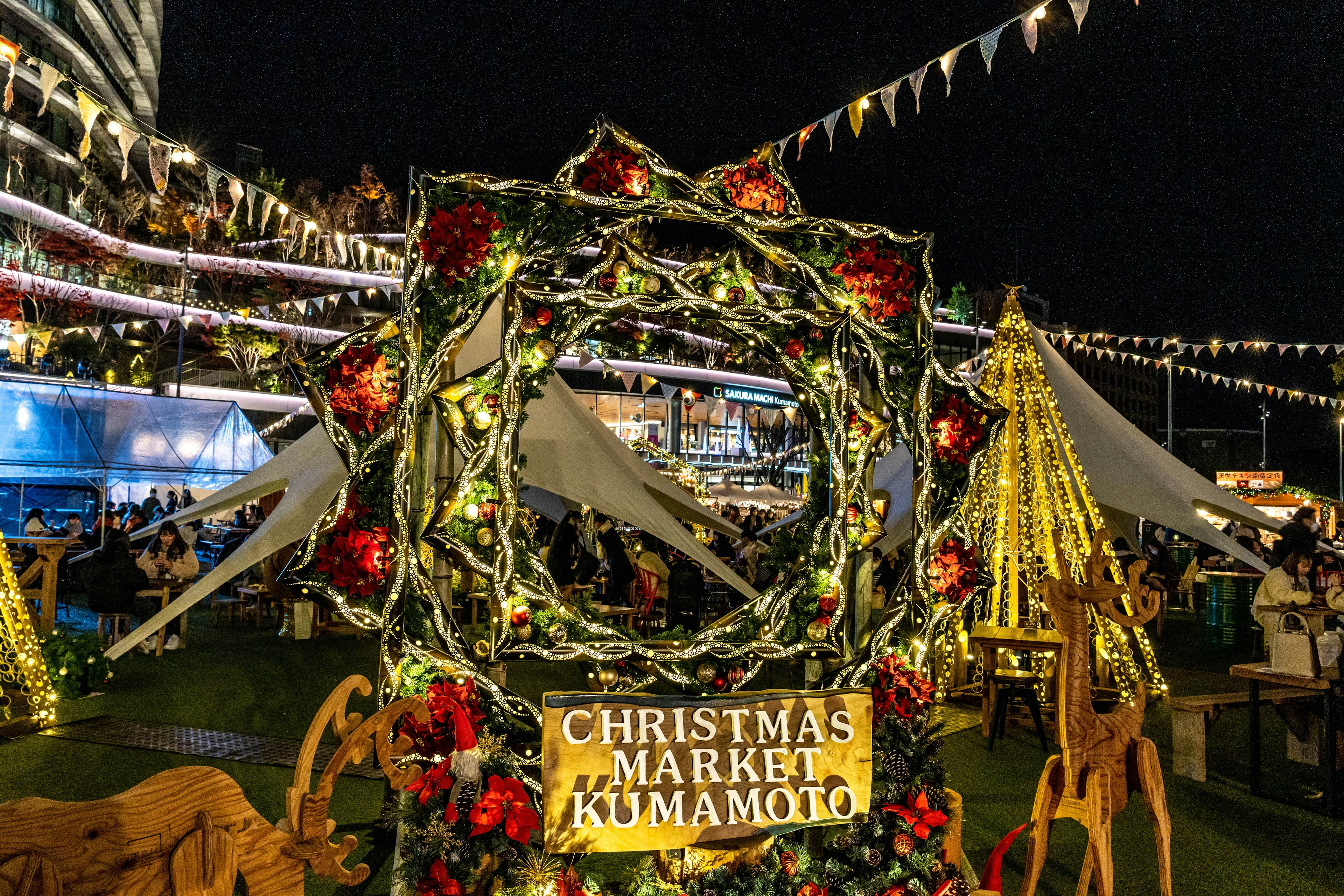 Corona decorativa de noche en el mercado de Navidad de Kumamoto con luces brillantes