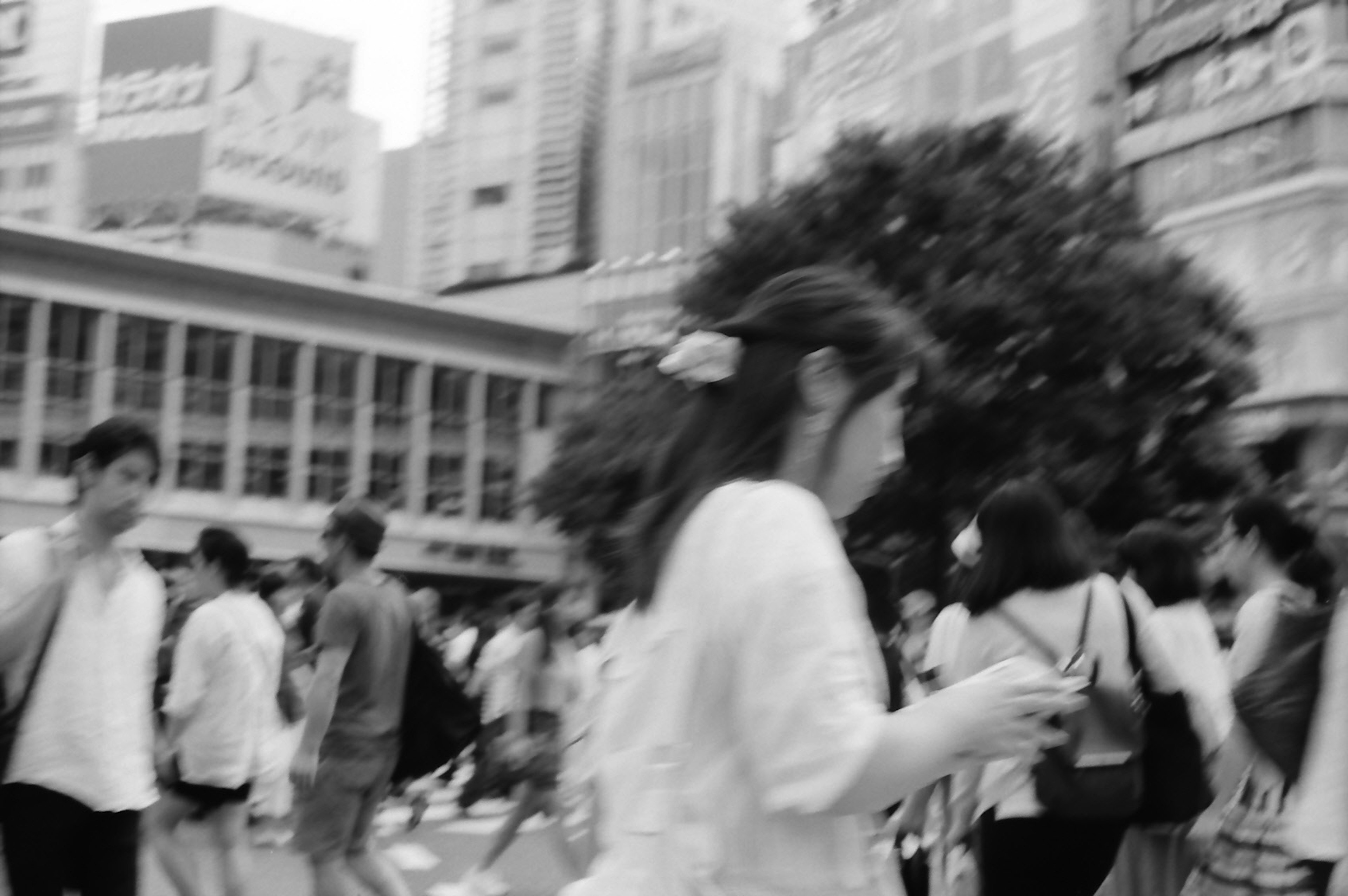 Foto en blanco y negro de personas caminando en una intersección urbana concurrida