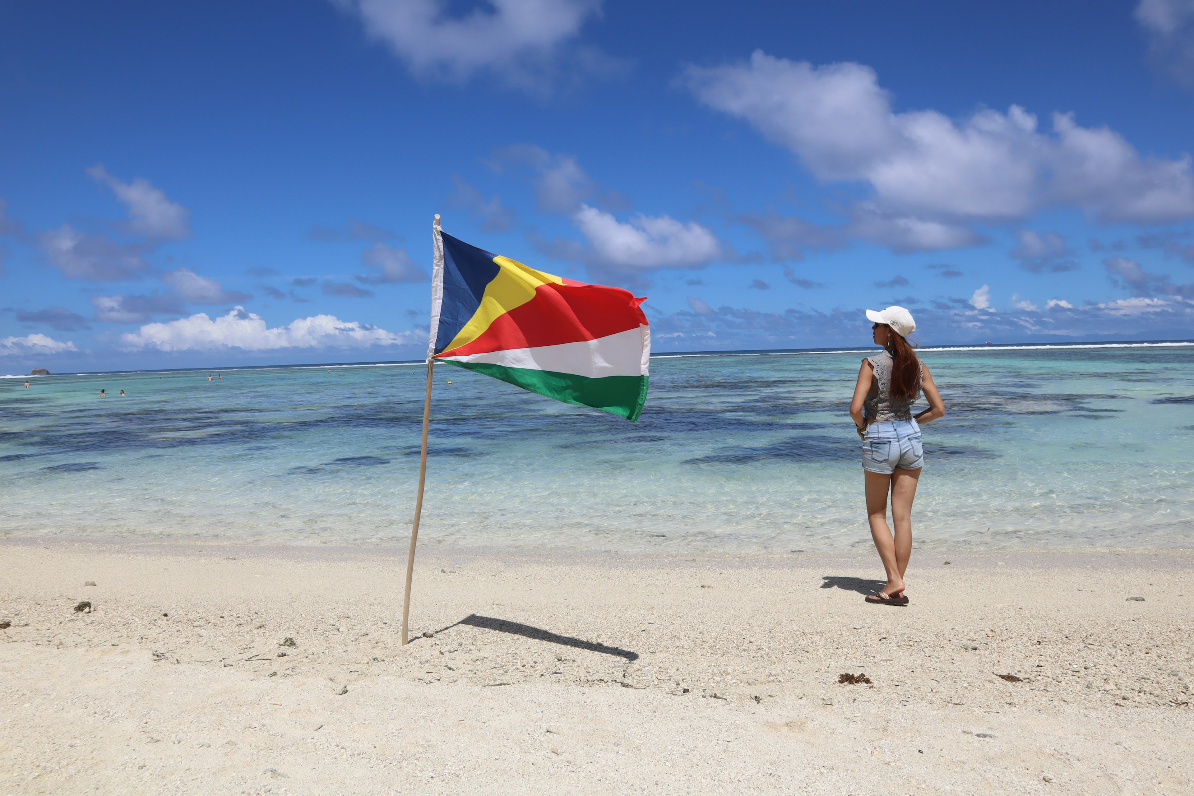 Woman gazing at the sea on a beach with the South Sudan flag