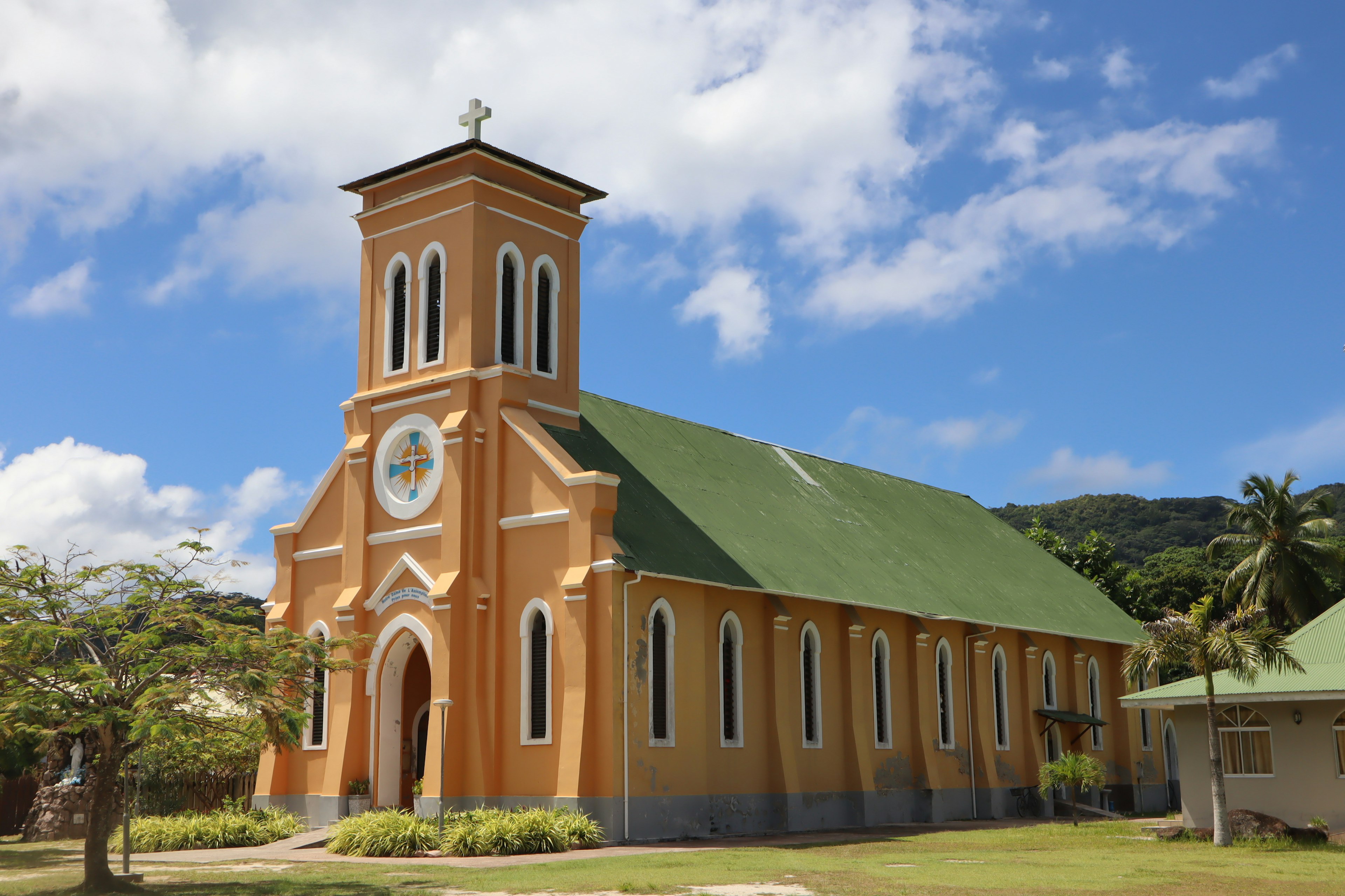 Hermoso edificio de iglesia con exterior naranja y techo verde