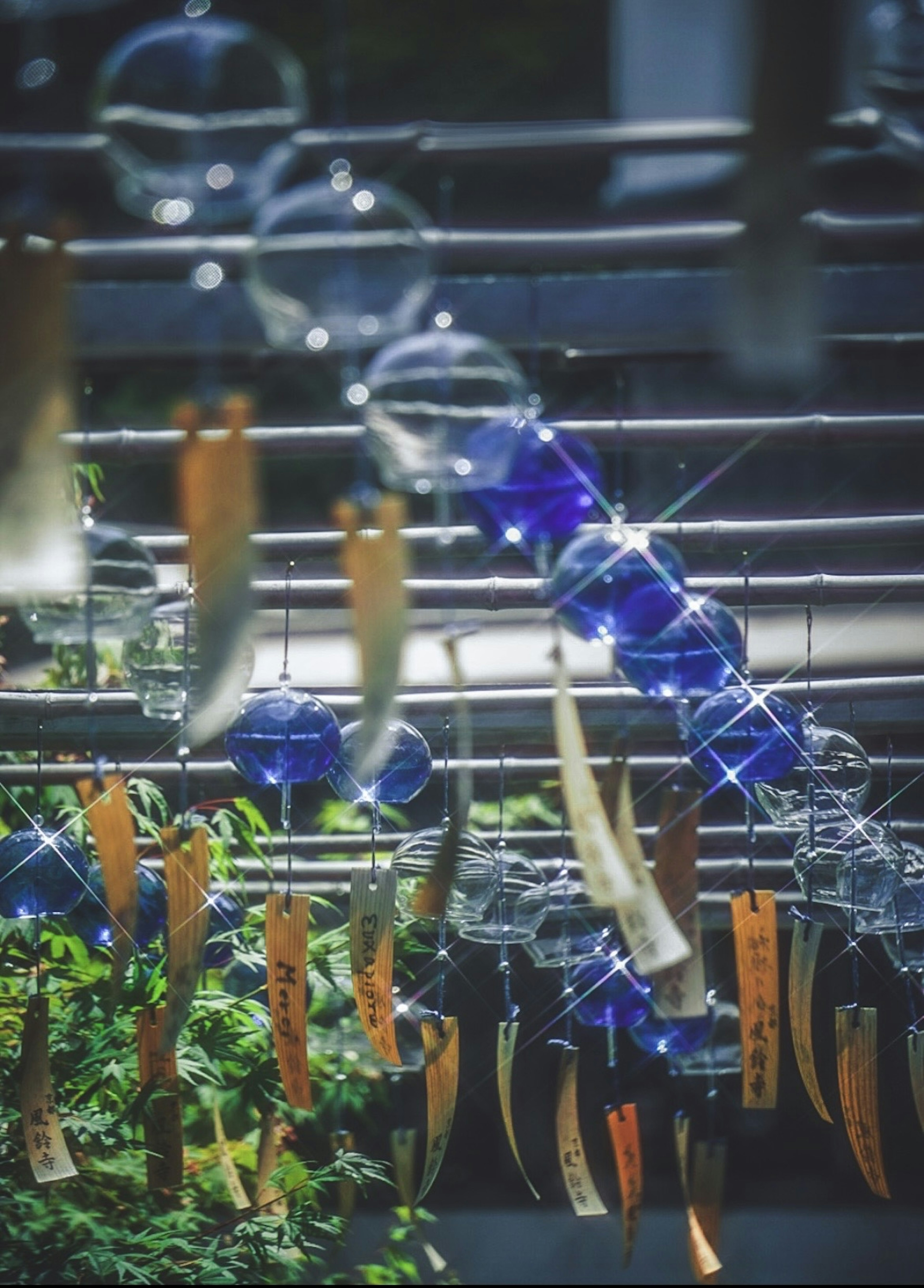 Blue wind chimes and wooden strips hanging in a serene setting