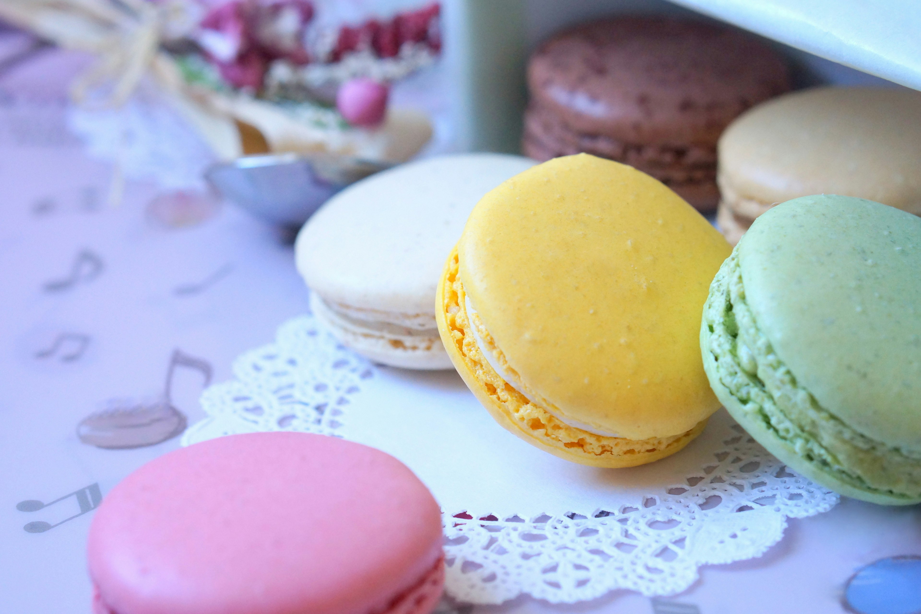 Bánh macaron nhiều màu sắc được sắp xếp trên lót bàn ren