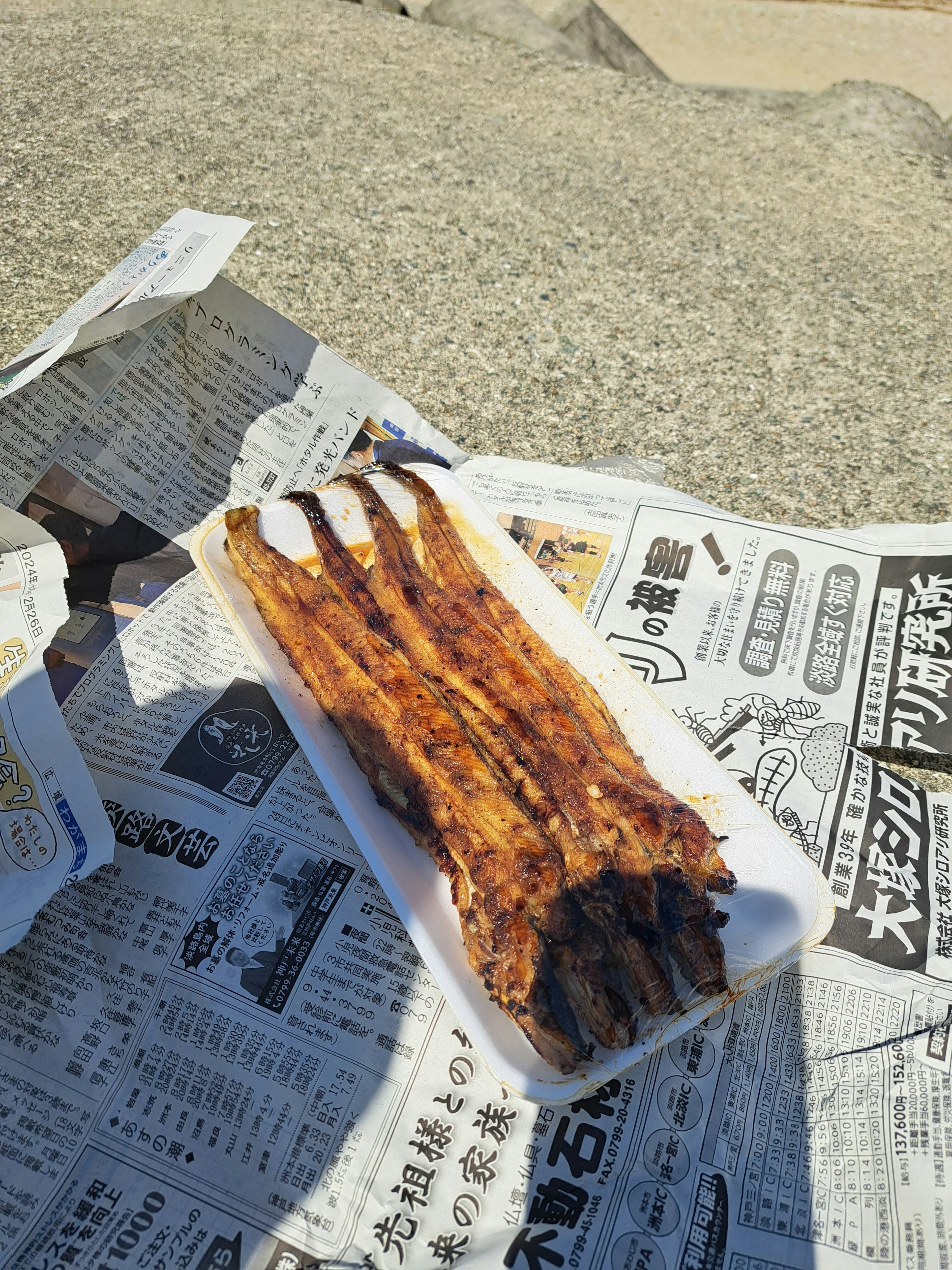 Pescado a la parrilla en un plato blanco sobre un periódico