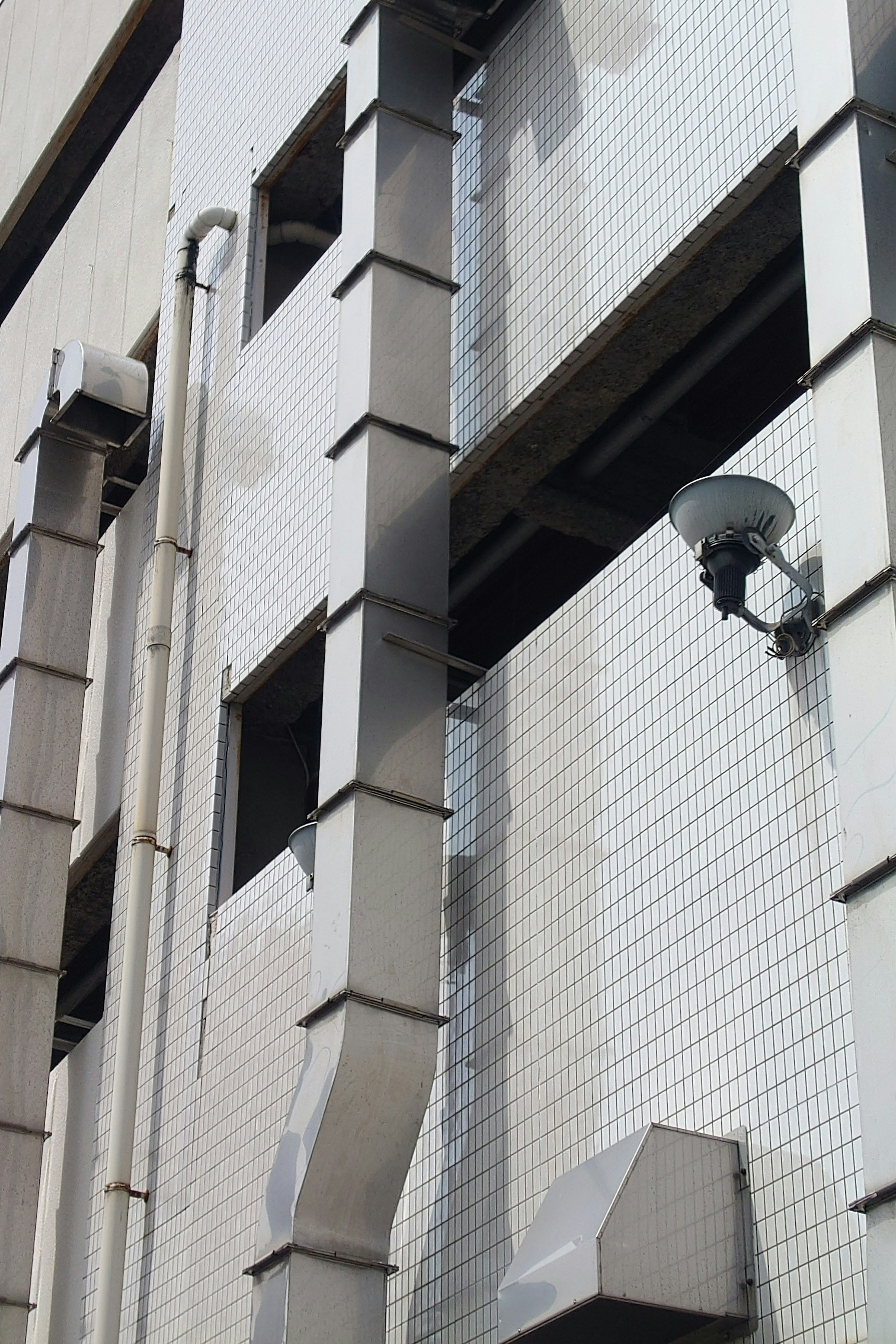 Vista detallada de conductos de escape y cámara de vigilancia en el exterior de un edificio