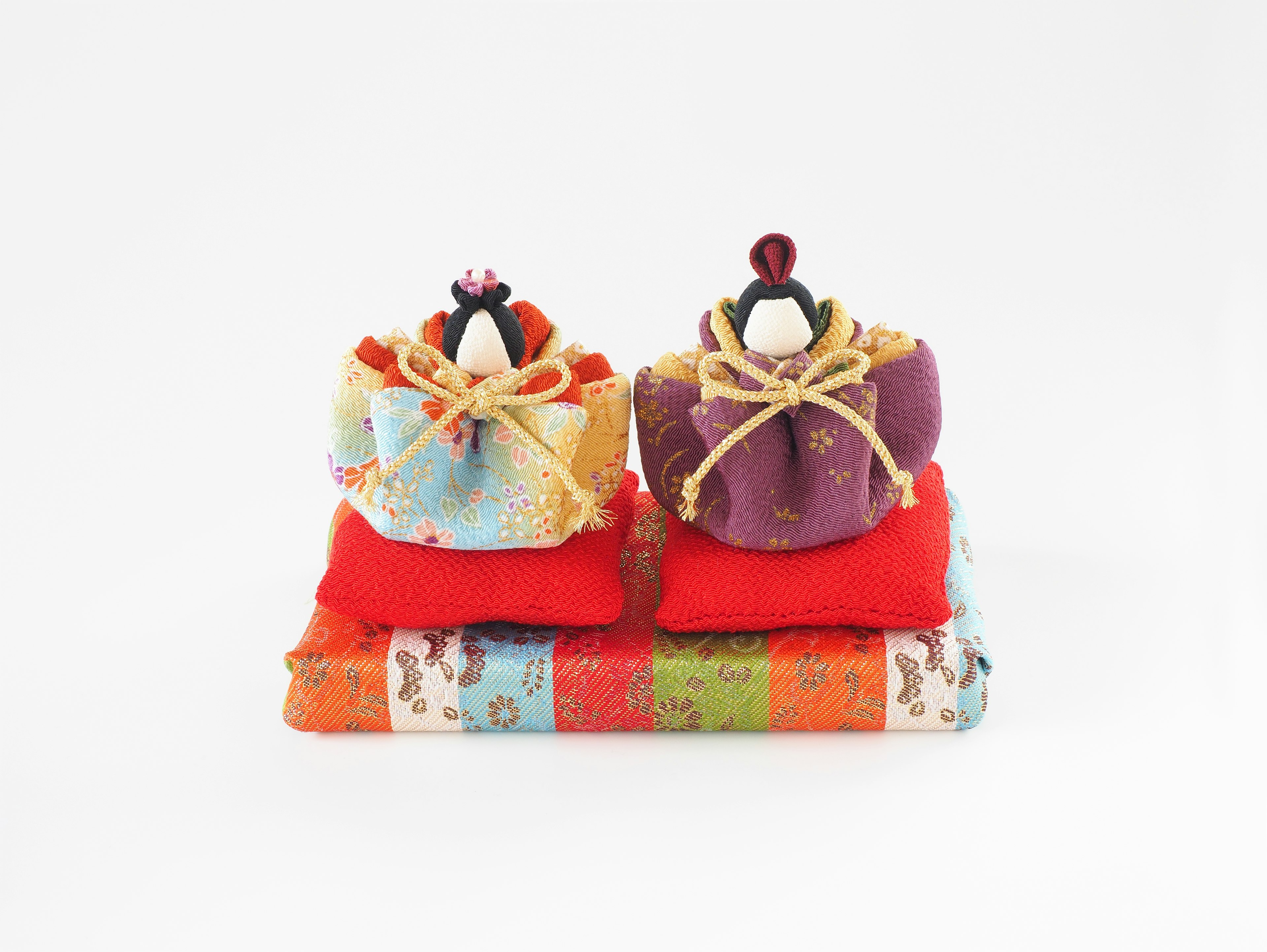 Traditional Japanese hina dolls placed on colorful fabric