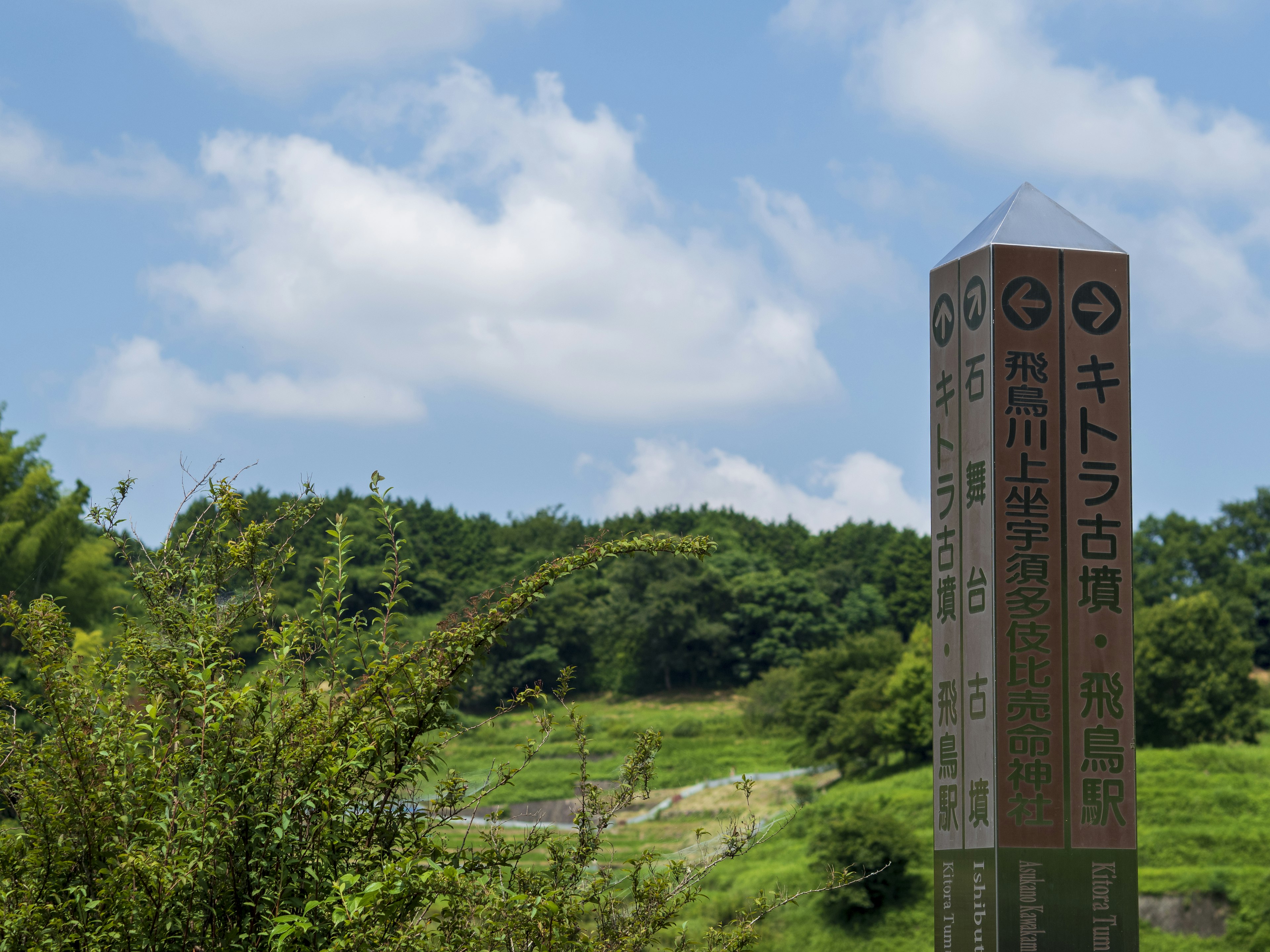 Señal direccional Kawako con paisaje de cielo azul