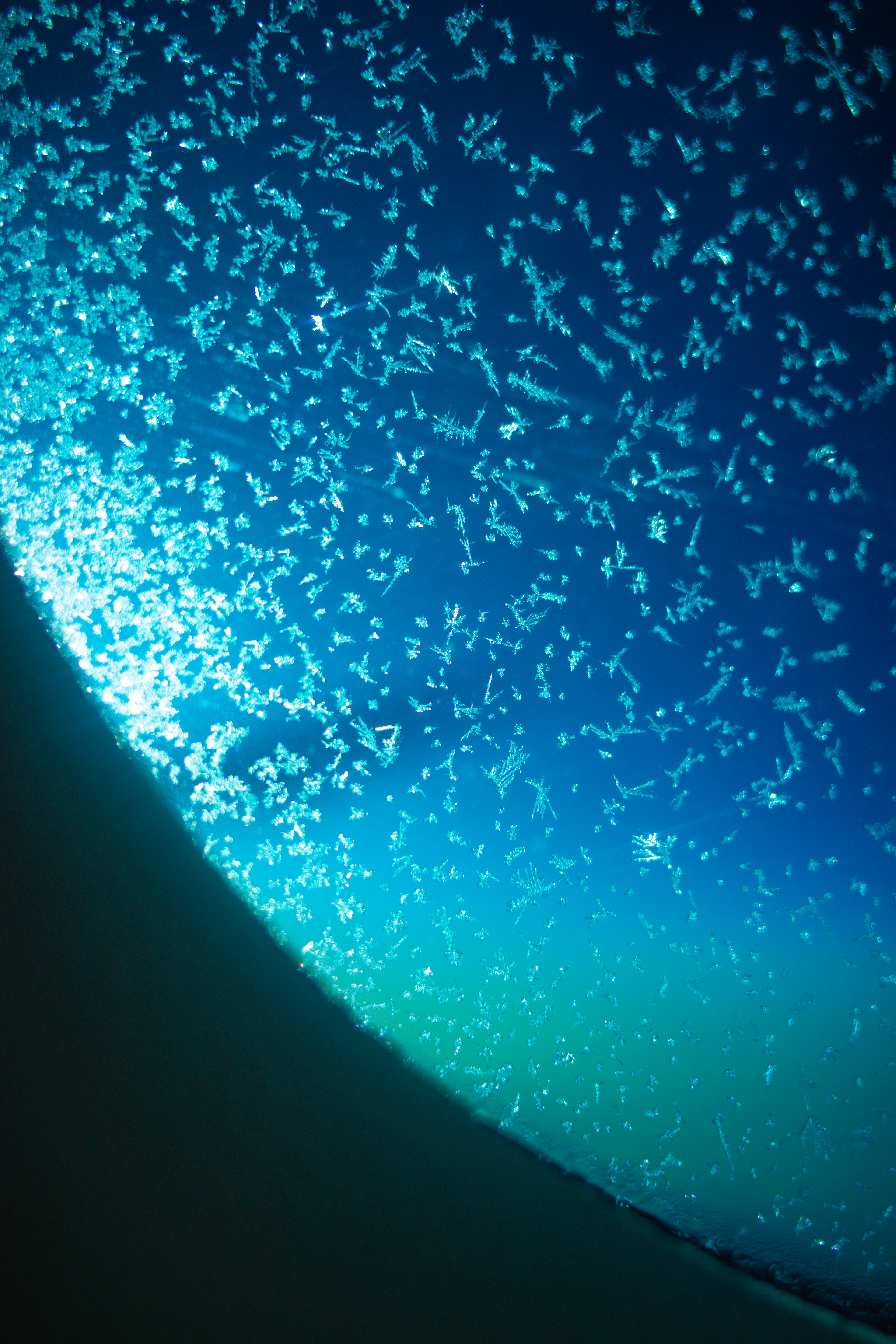 Riflessione della luce e bolle nell'acqua blu