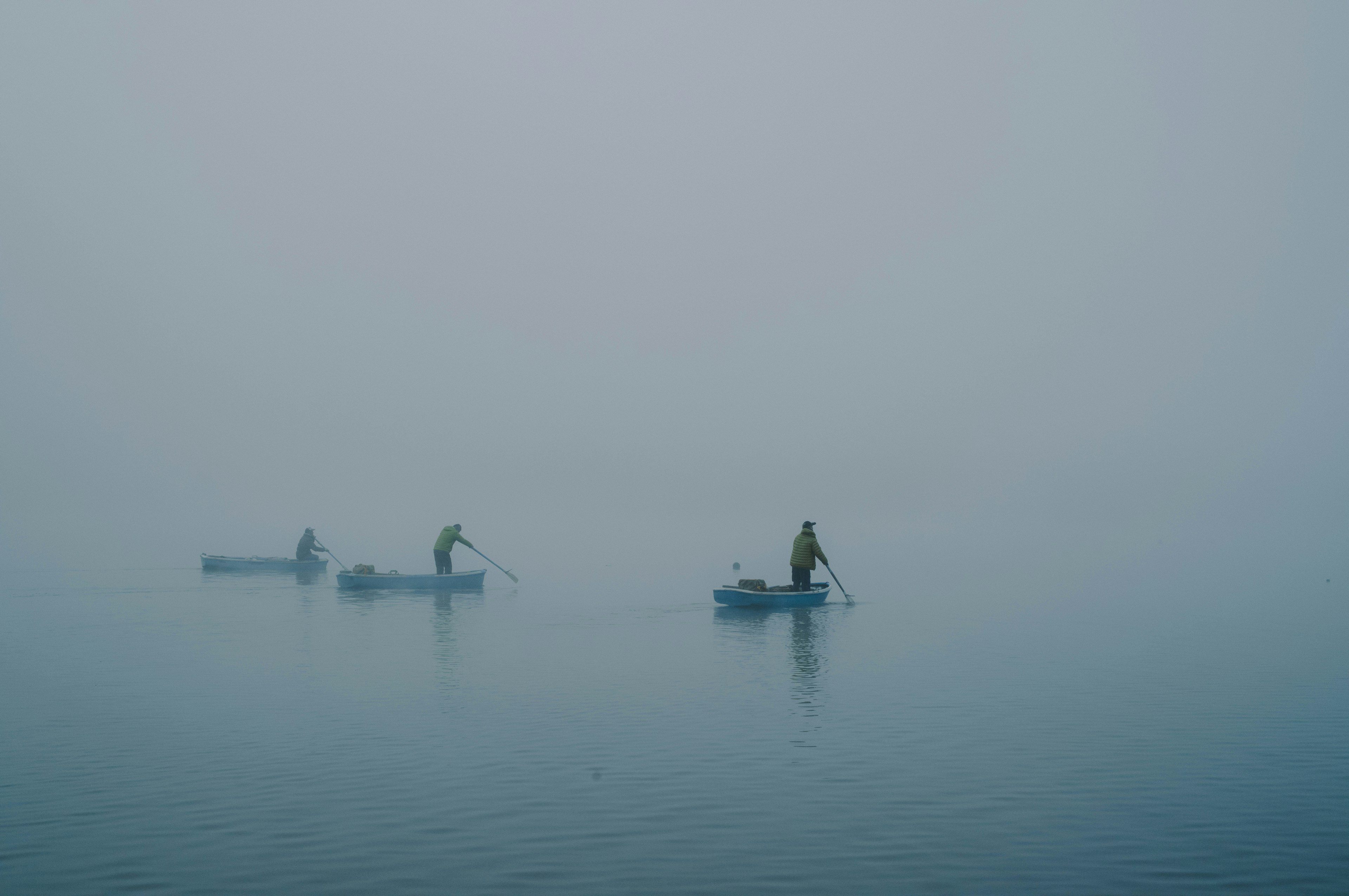 Fishermen in small boats fishing in fog