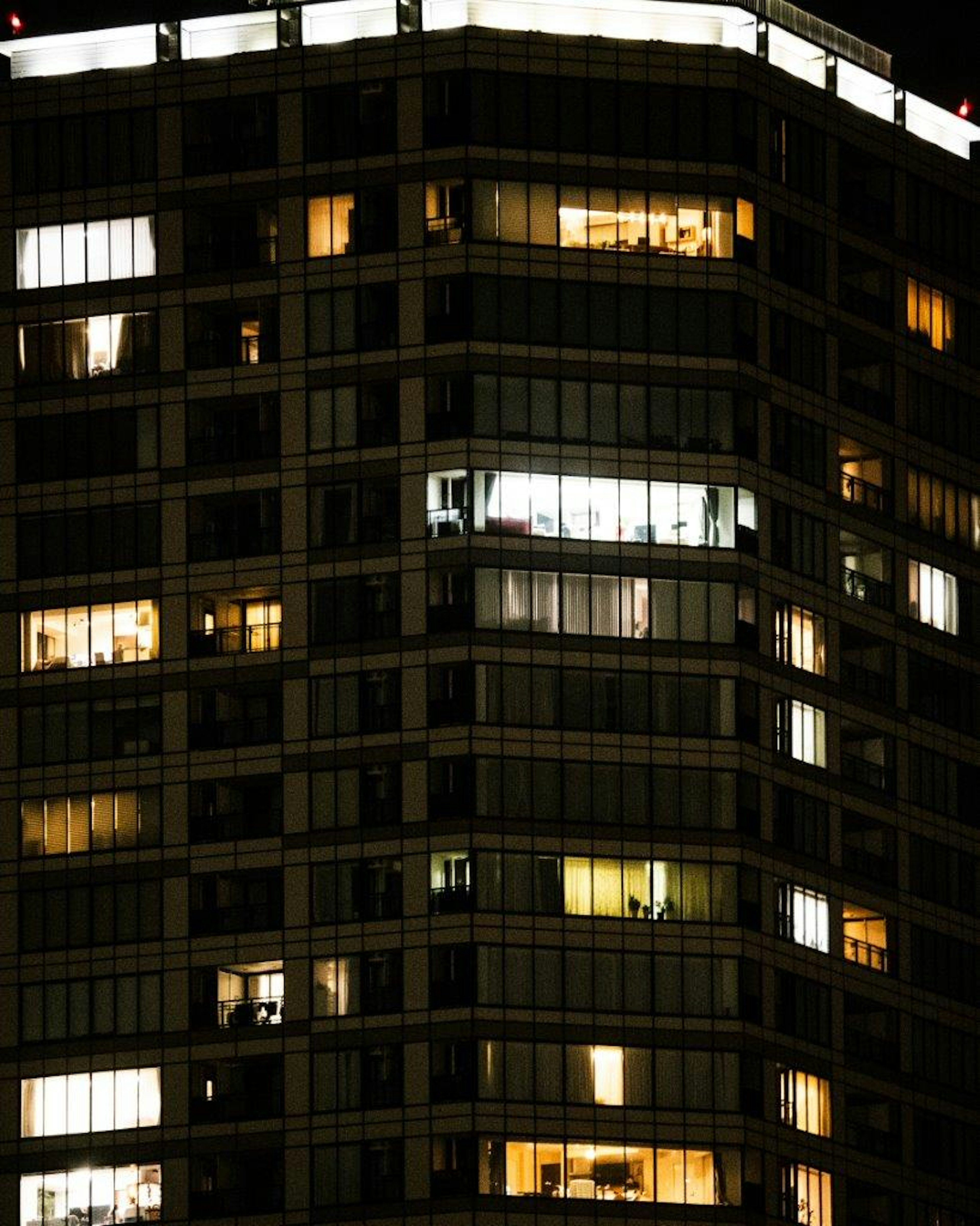 Beleuchtete Fenster eines Wolkenkratzers bei Nacht