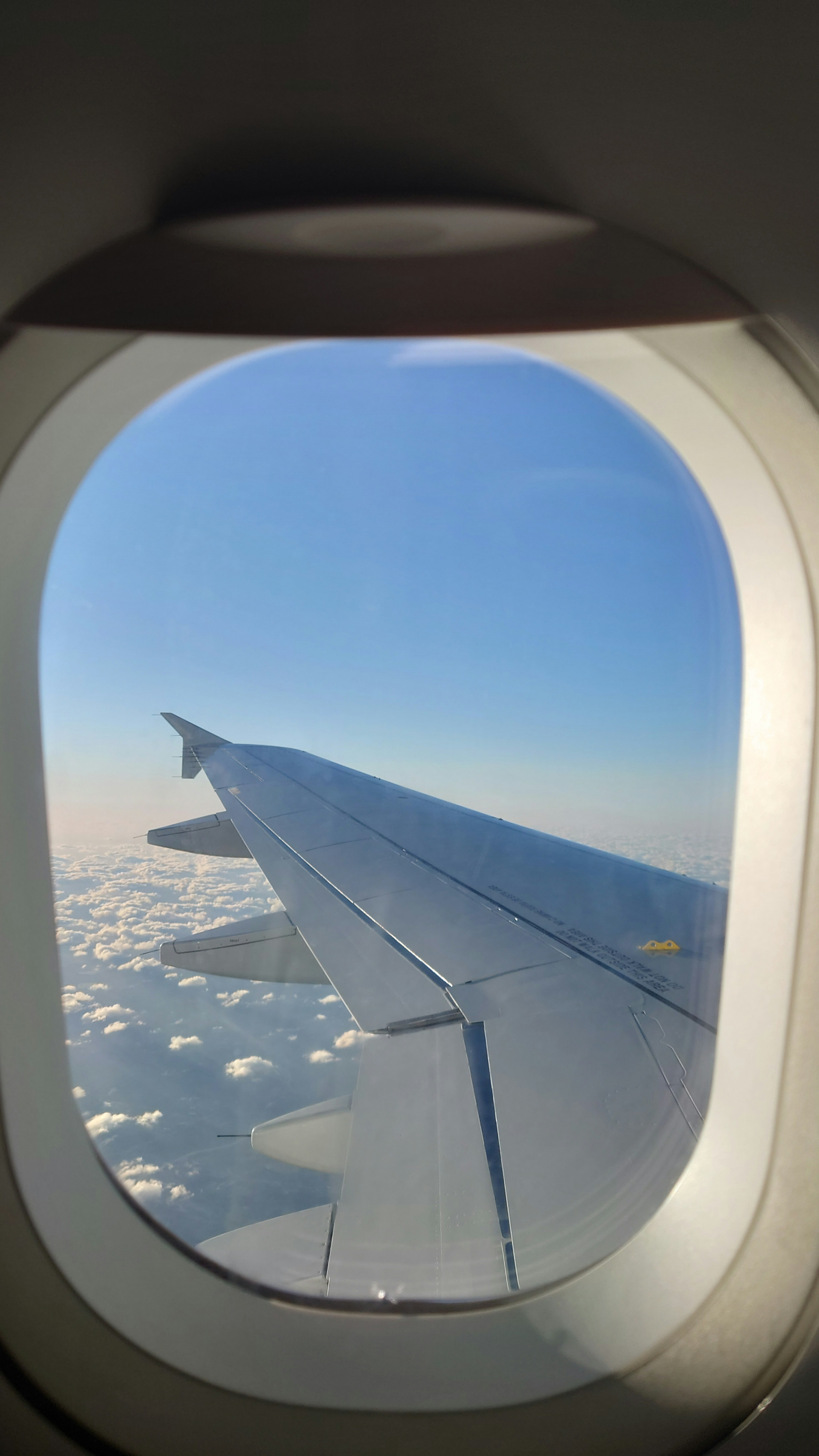 飛行機の窓から見た翼と雲の景色