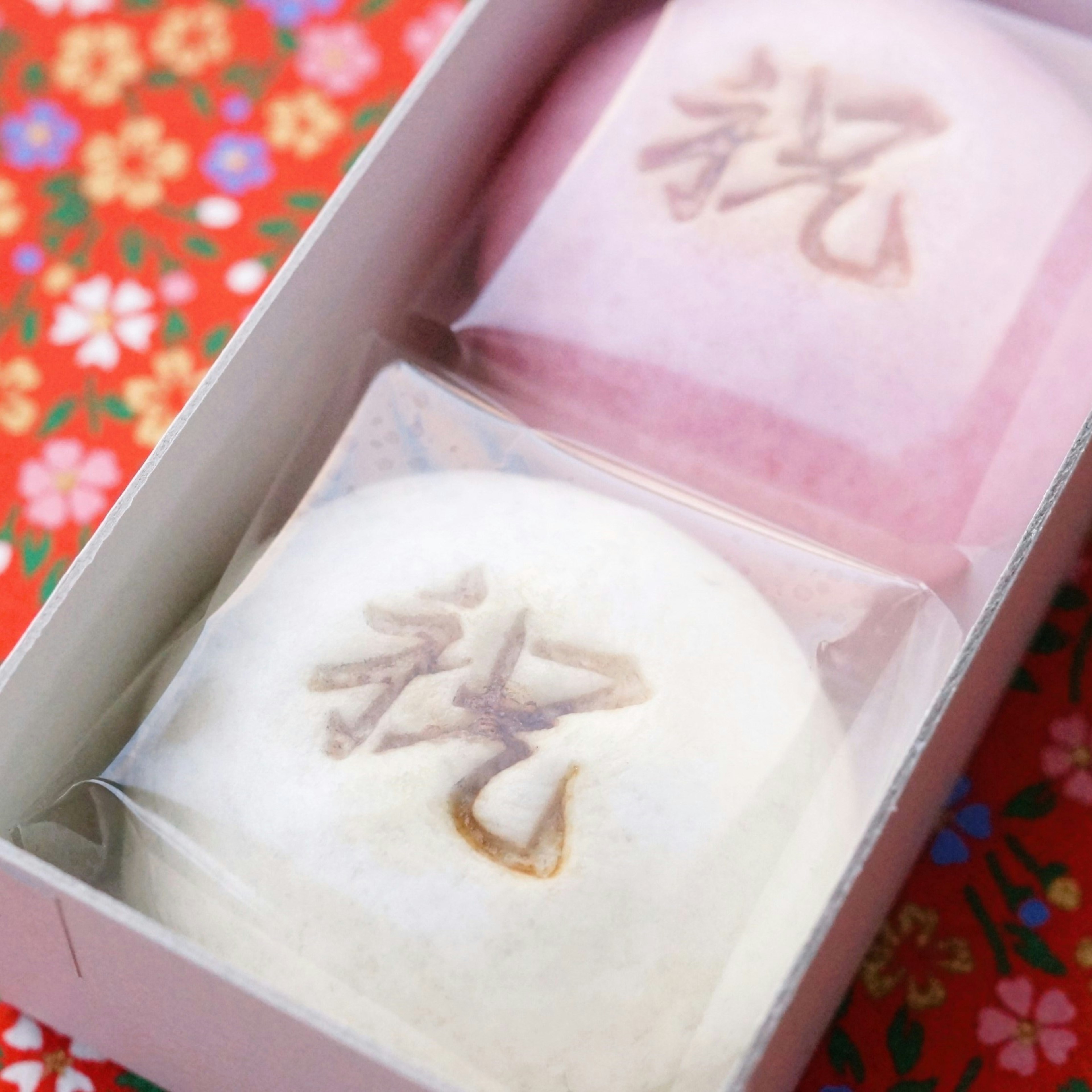 Japanese sweets assortment white and pink buns with floral background