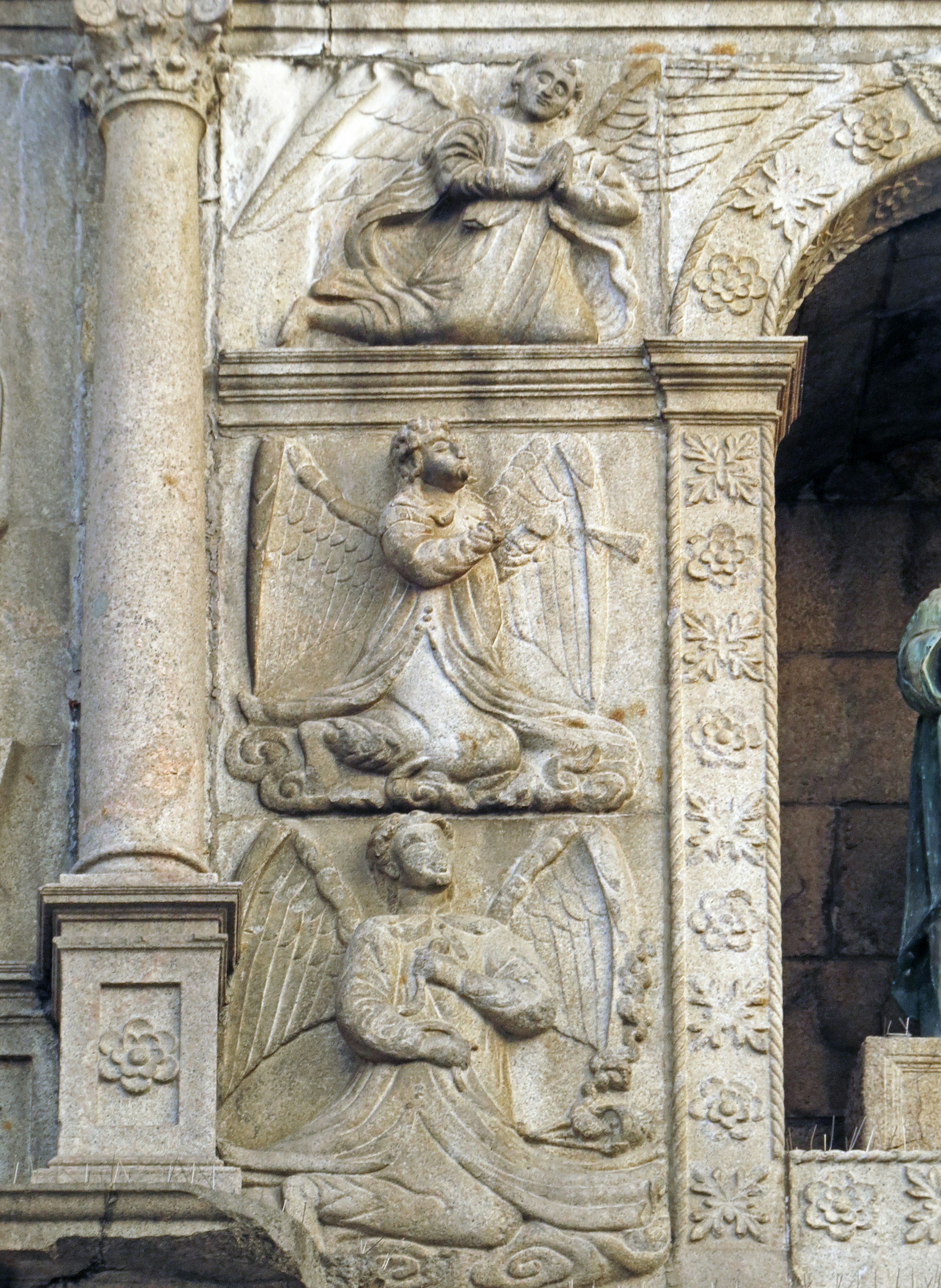 Reliefskulptur von Engeln und Heiligen an einer Kirchenwand