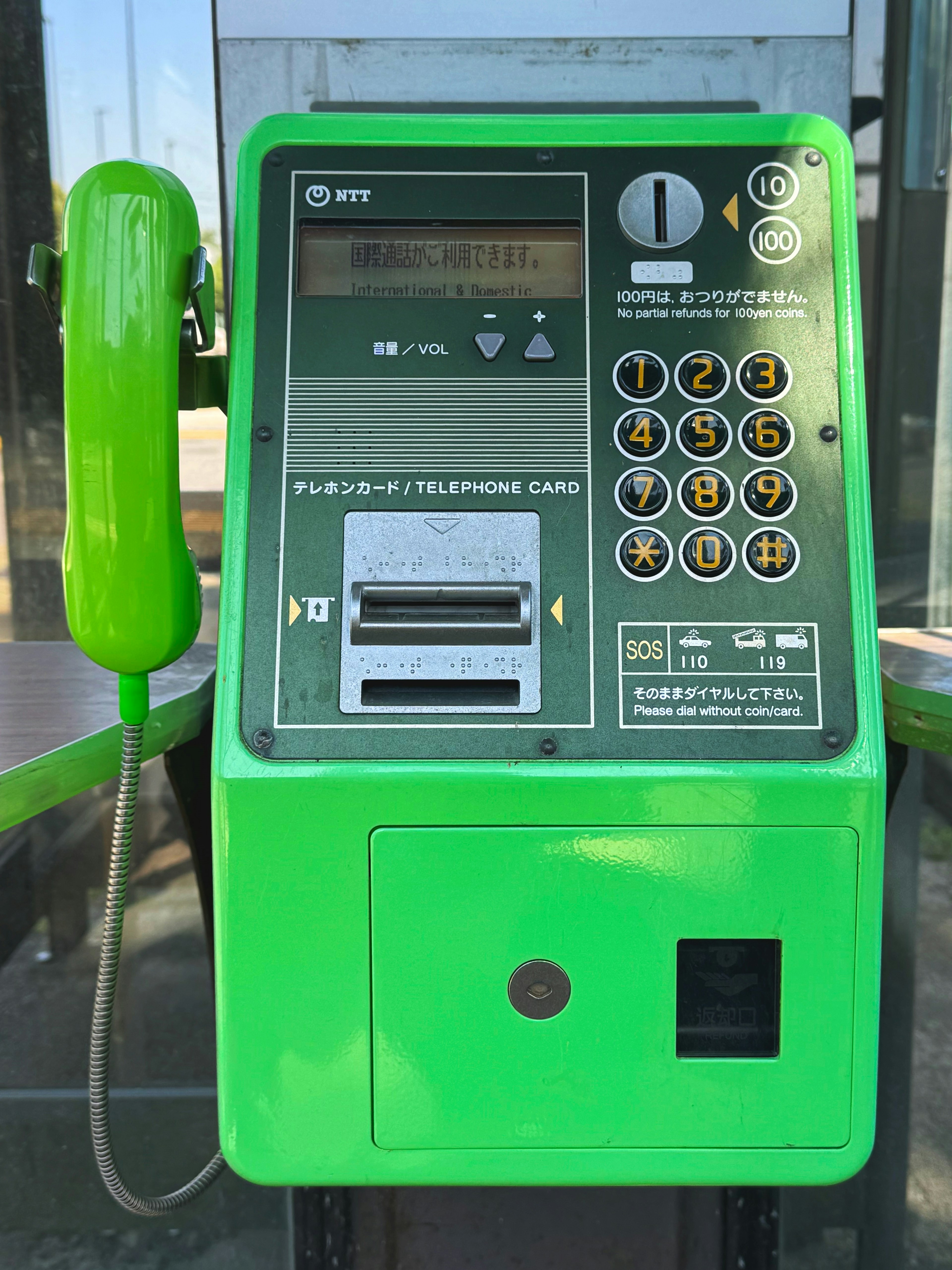 Teléfono público verde con teclado y ranura para monedas