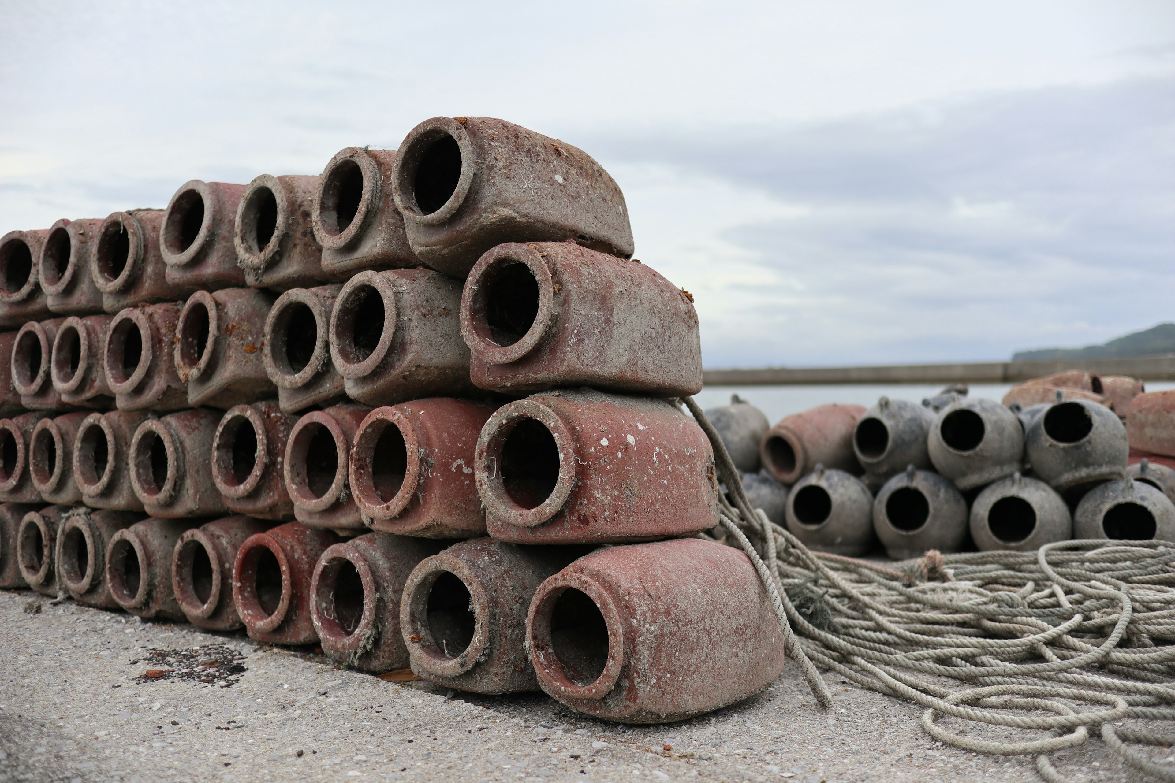 Blok silindris beton yang ditumpuk di lingkungan pesisir