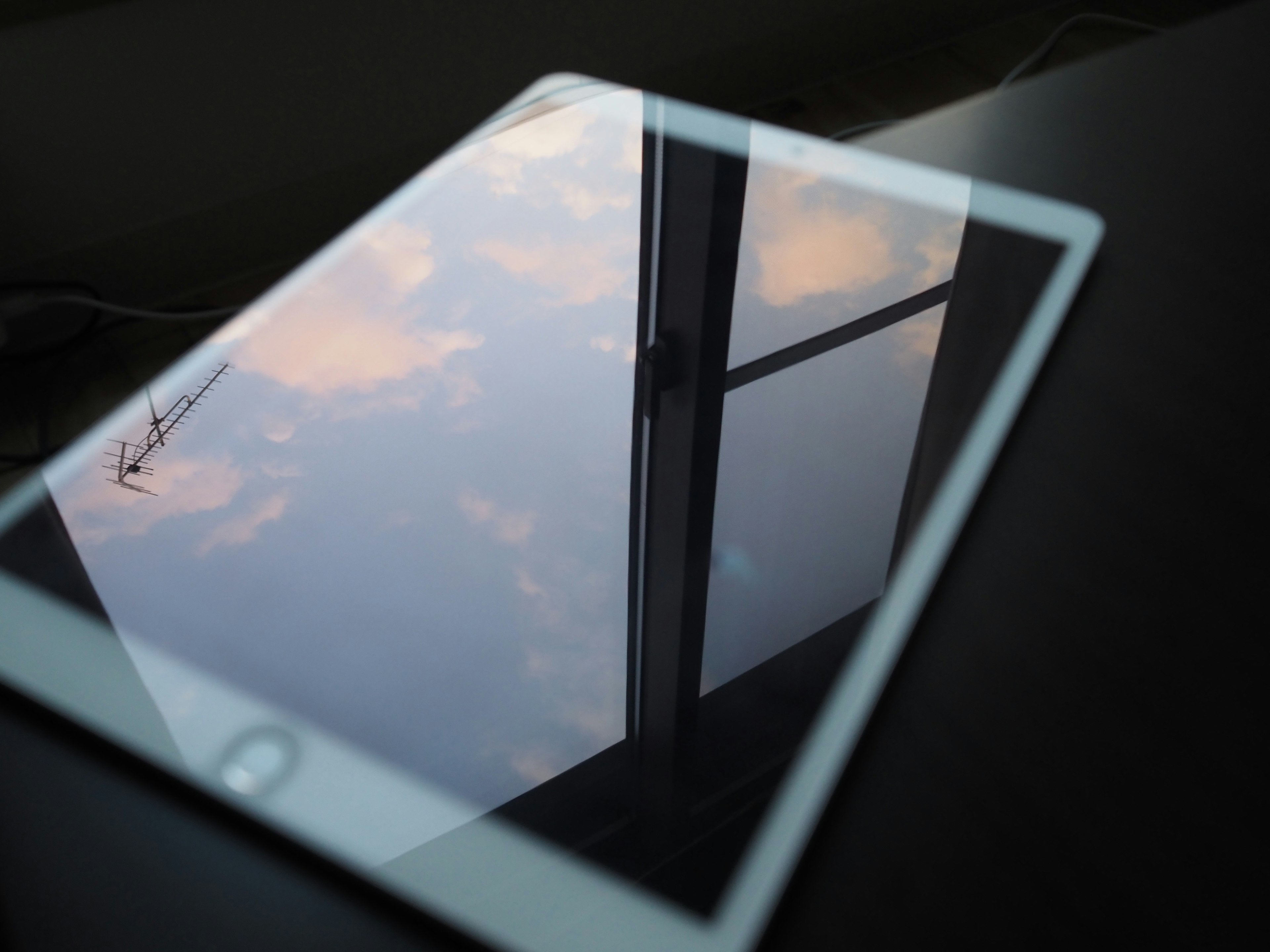 Tablette réfléchissant le ciel sur une table