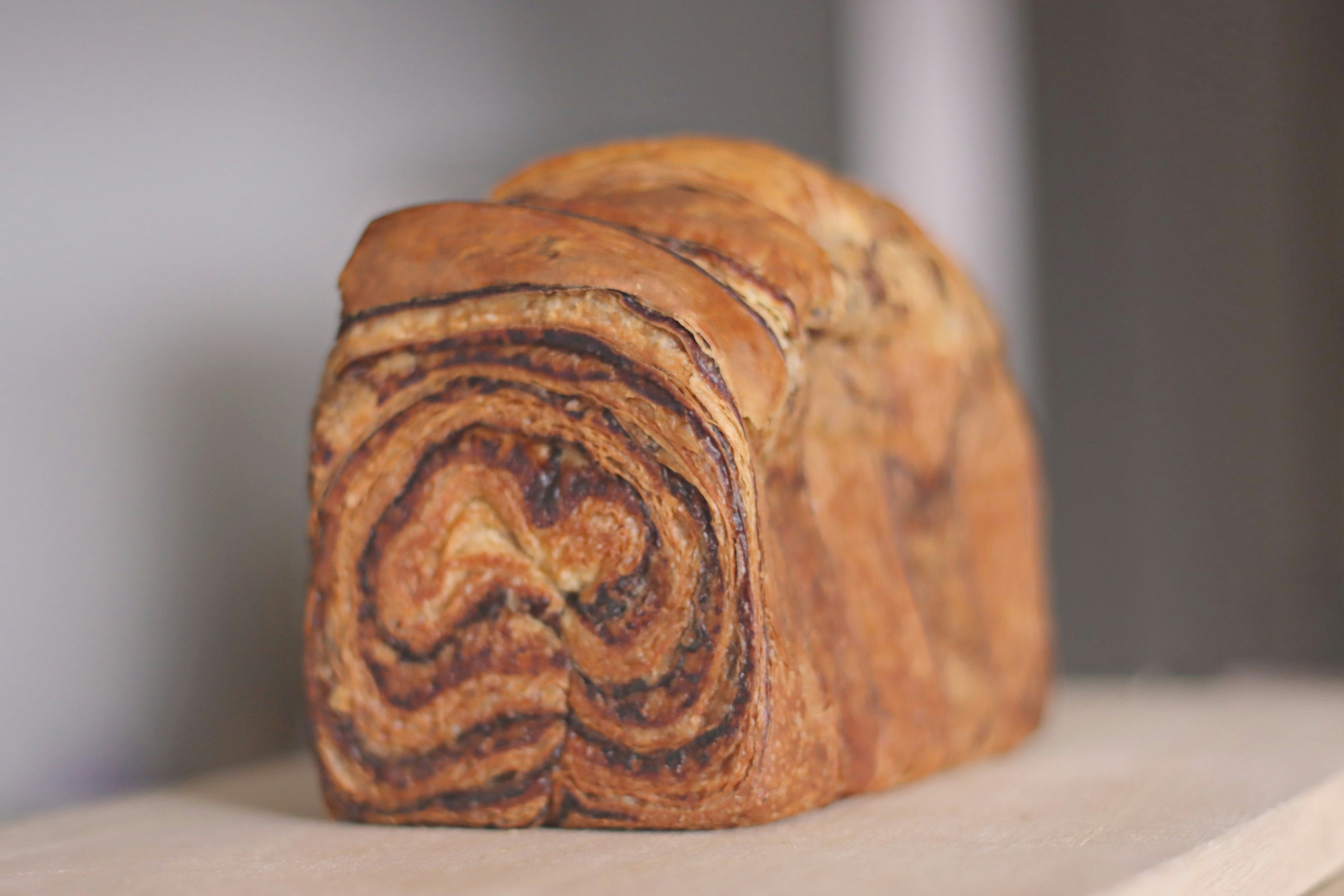 A delicious cinnamon swirl bread loaf placed on a wooden counter